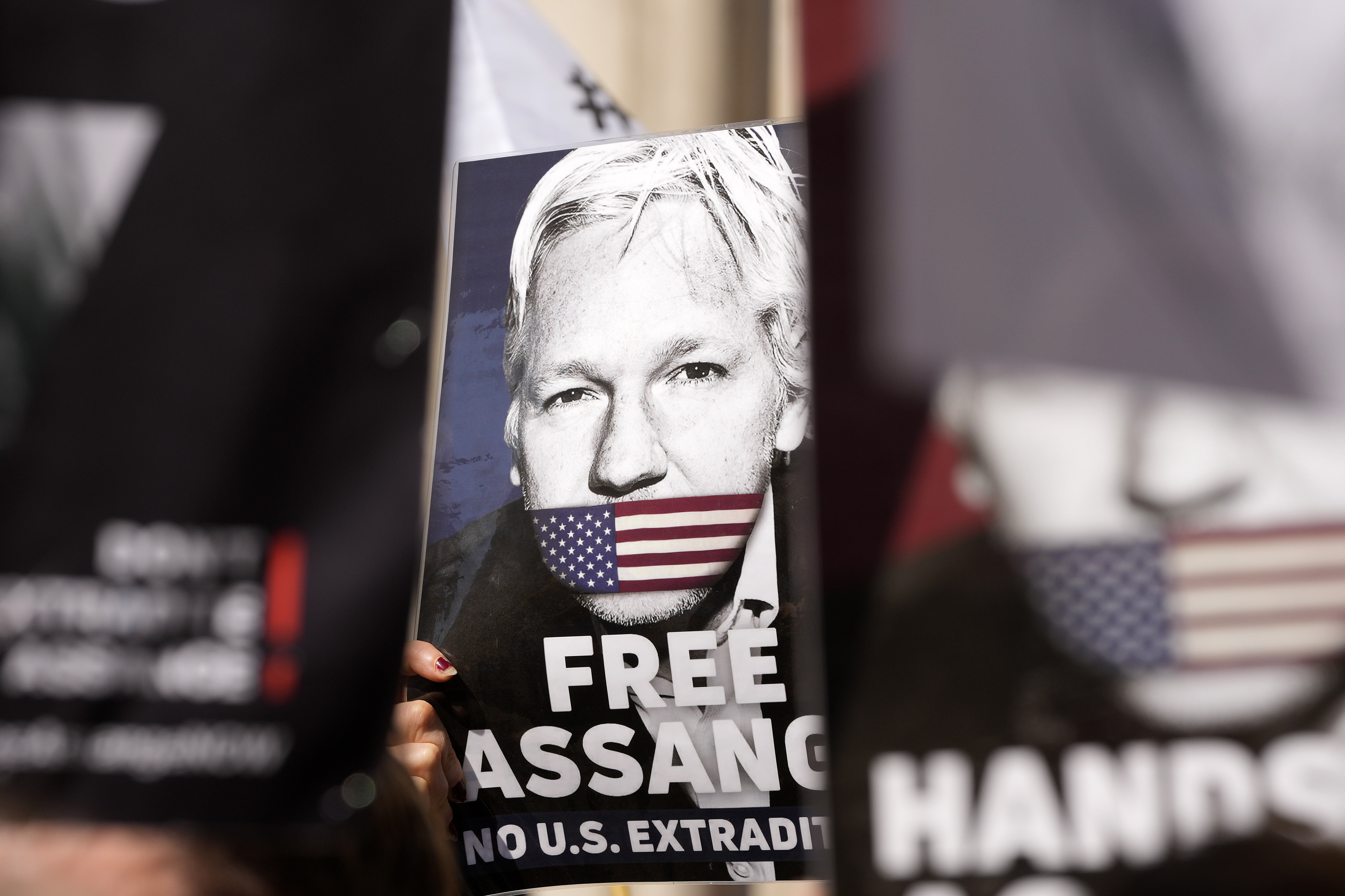 Protesters hold placards outside the High Court in London, Monday, May 20, 2024. WikiLeaks founder Julian Assange faces a hearing Monday in the High Court in London that could end with him being sent to the U.S. to face espionage charges, or provide him another chance to appeal his extradition. The outcome will depend on how much weight judges give to assurances U.S. officials have provided that Assange's rights won't be trampled if he goes on trial. (AP Photo/Kin Cheung)