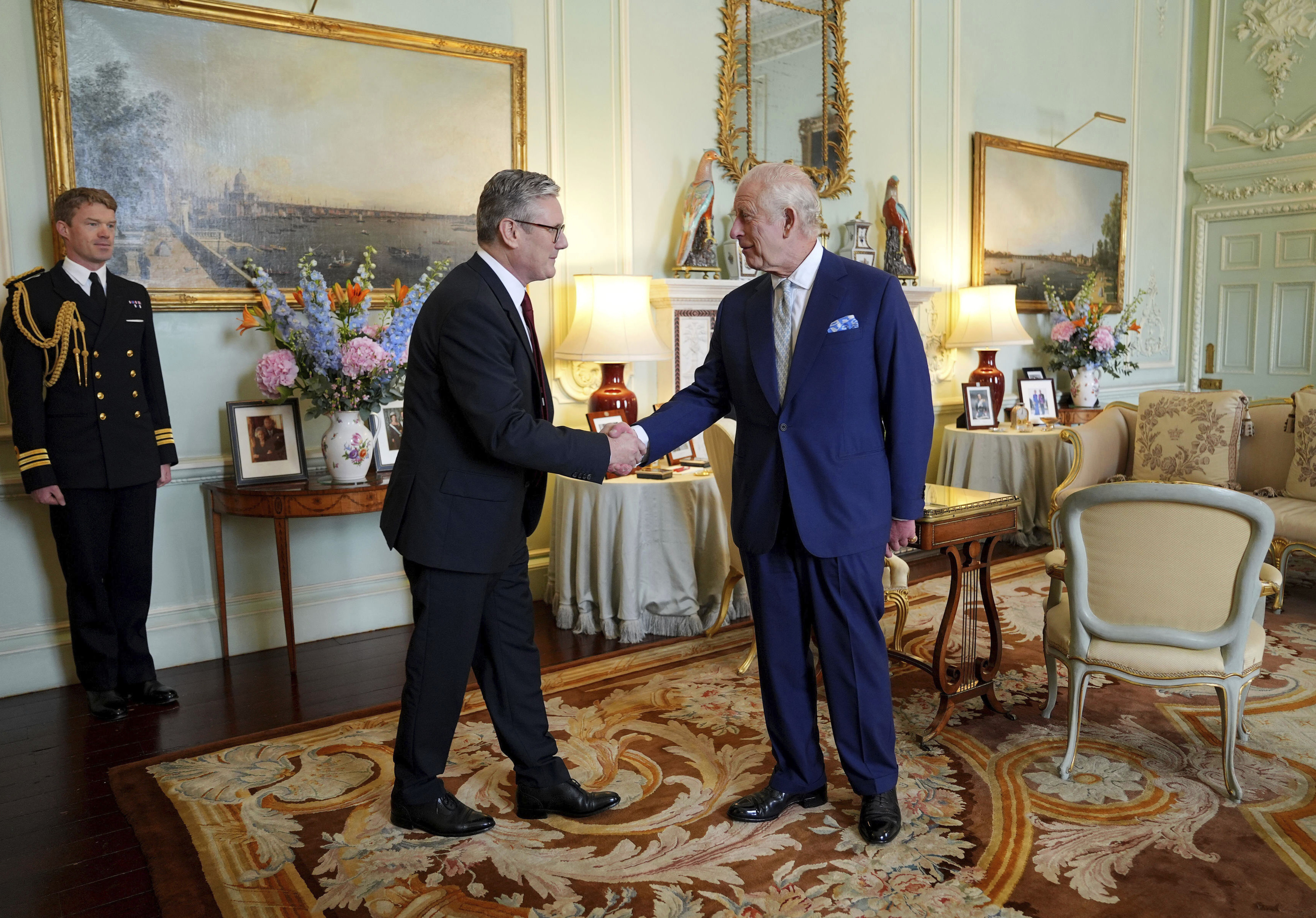 Britain's King Charles III, right, shakes hands with Keir Starmer where he invited the Labour Party leader to become prime minister and to form a new government, following the landslide general election victory for the Labour Party, in London, Friday, July 5, 2024. (Yui Mok, Pool Photo via AP)