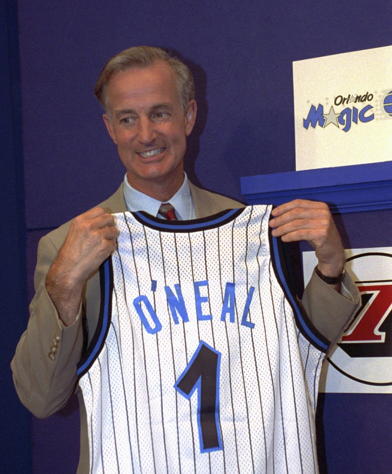 FILE - Orlando Magic President and General manager Pat Williams grins while holding up a jersey bearing the name O'Neal and the number 1, at the NBA draft lottery in Secaucus, N.J. May 17, 1992. Williams, a co-founder of the Orlando Magic and someone who spent more than a half-century working within the NBA, died Wednesday, July 17, 2024, from complications related to viral pneumonia, the team announced. (AP photo/Bill Kostroun, File)