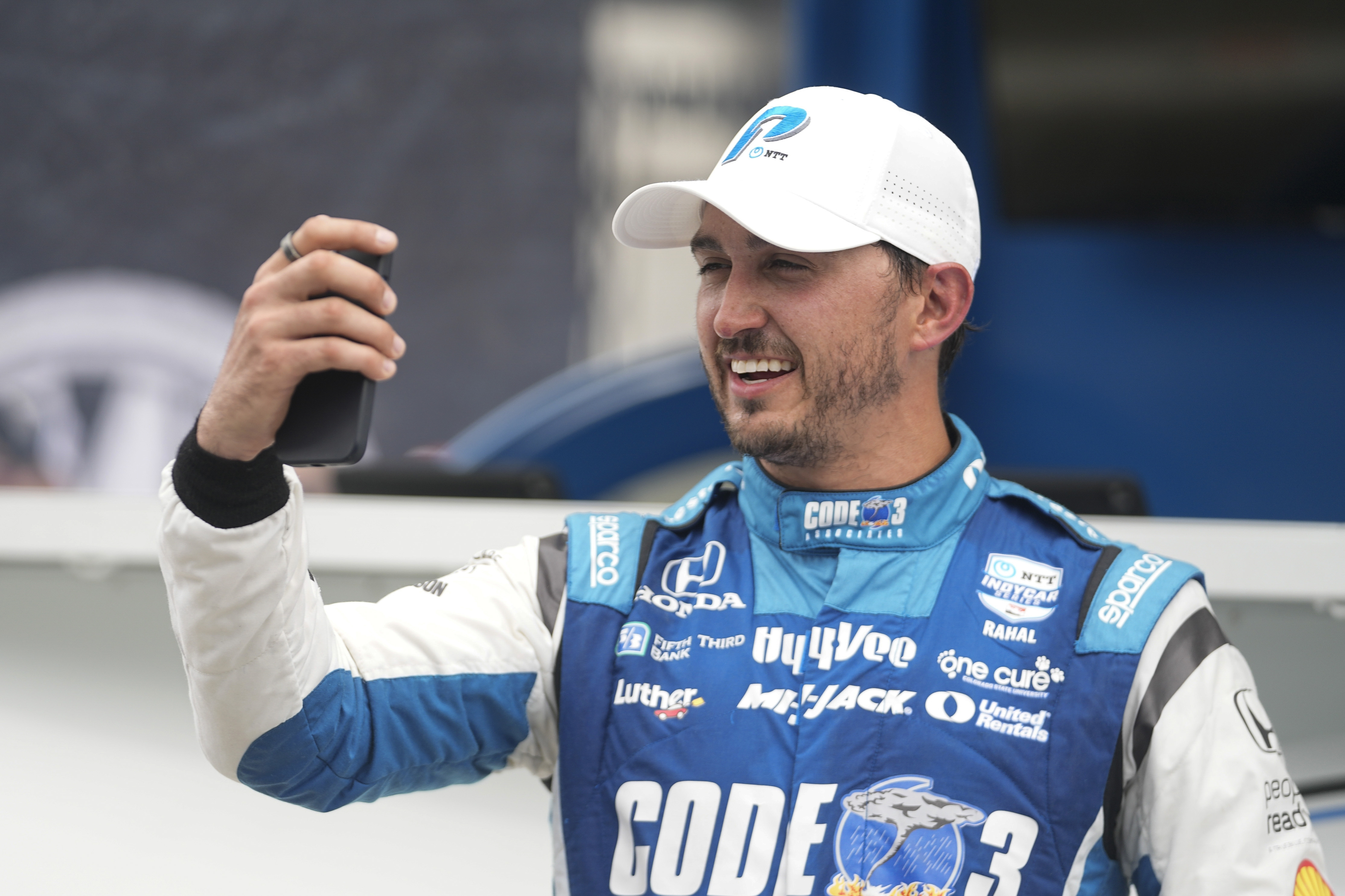 Graham Rahal records a message after winning the pole for the IndyCar Indianapolis GP at Indianapolis Motor Speedway, Friday, Aug. 11, 2023, in Indianapolis. (AP Photo/Darron Cummings)