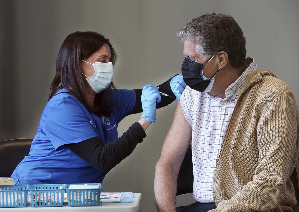 Nurse Kerry Stanchina, of The Wellness Company, administers a COVID-19 vaccine to Rhode Island Lt. Gob. Daniel J. McKee, Tuesday, March 2, 2021, at the Dunkin Donuts Center in Providence, R.I. (Bob Breidenbach/Providence Journal via AP)