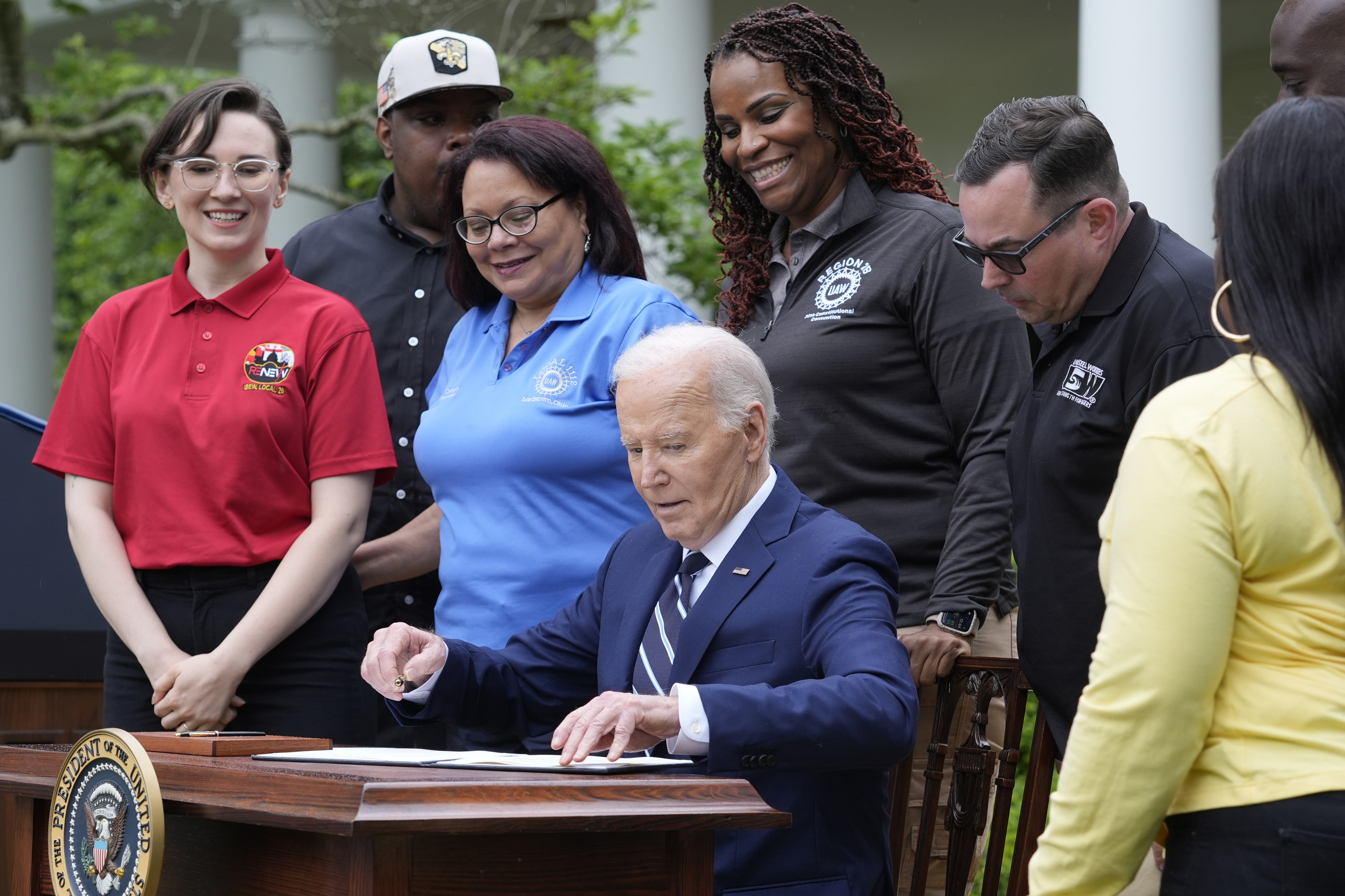 President Joe Biden sits down to sign a document in the Rose Garden of the White House in Washington, Tuesday, May 14, 2024, imposing major new tariffs on electric vehicles, semiconductors, solar equipment and medical supplies imported from China. (AP Photo/Susan Walsh)