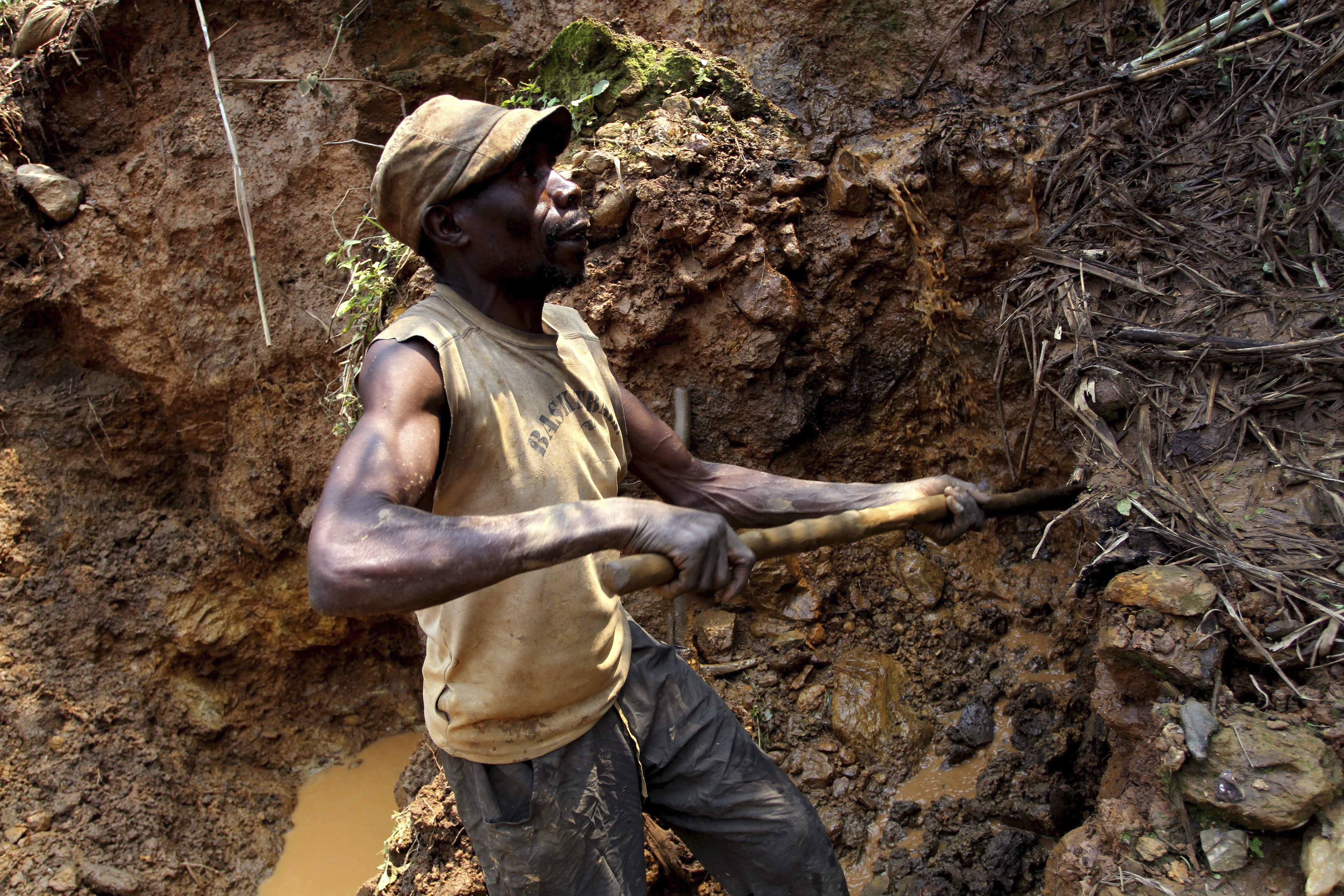FILE - One of the few remaining miners digs out soil which will later be filtered for traces of cassiterite, the major ore of tin, at Nyabibwe mine, in eastern Congo, on Aug. 17, 2012. The governor of the South Kivu province in eastern Congo on Friday ordered the suspension of all mining activities in order to “restore order” in the mineral-rich region plagued by violence from armed groups. (AP Photo/Marc Hofer, File)
