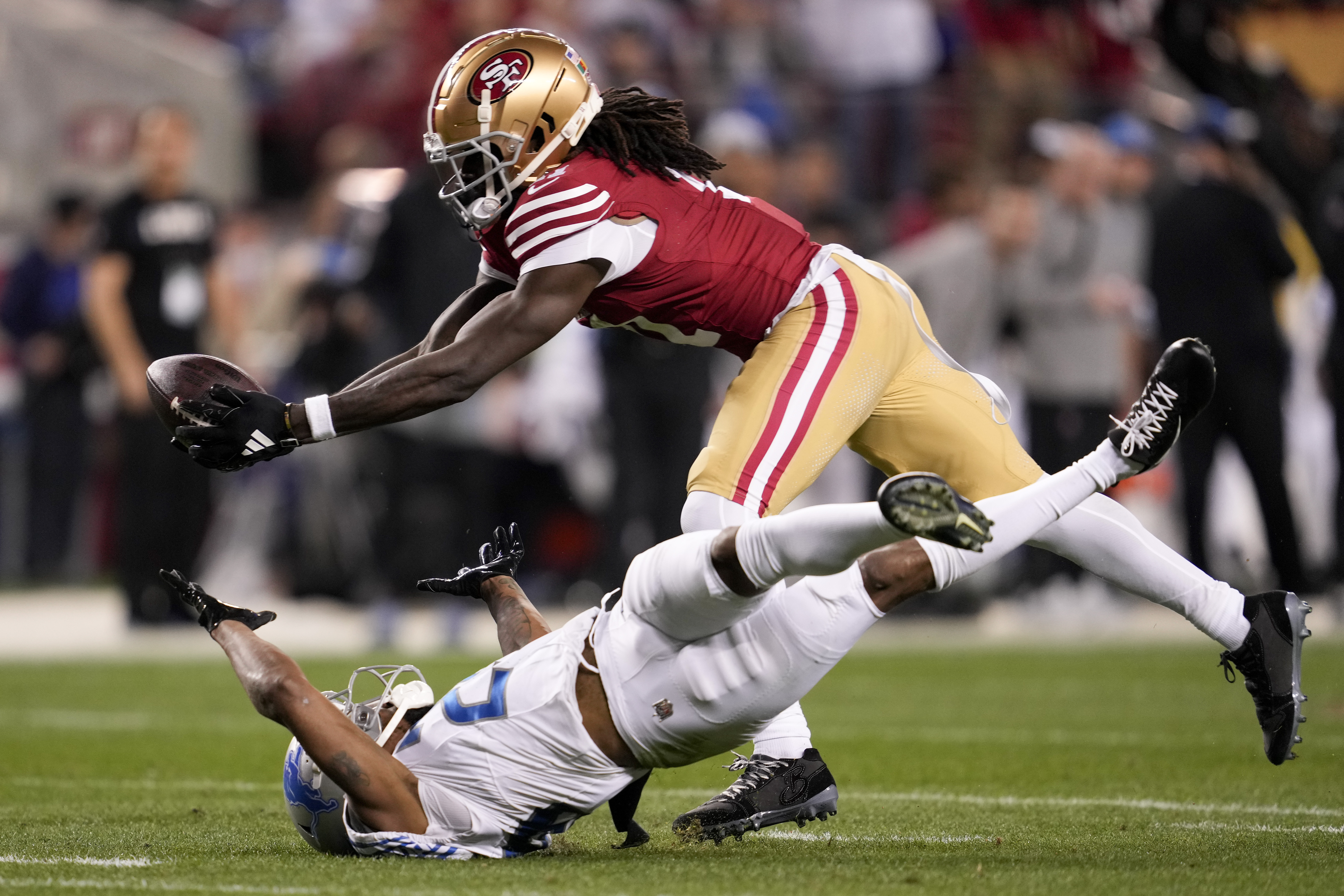 FILE - San Francisco 49ers wide receiver Brandon Aiyuk, top, catches a pass against Detroit Lions cornerback Kindle Vildor (29) during the second half of the NFC Championship NFL football game in Santa Clara, Calif., Sunday, Jan. 28, 2024. Brandon Aiyuk has requested a trade from the San Francisco 49ers because the two sides haven’t made progress on a new contract, a person familiar with the star wide receiver’s decision told The Associated Press on Tuesday, July 16.(AP Photo/Godofredo A. Vasquez, File)