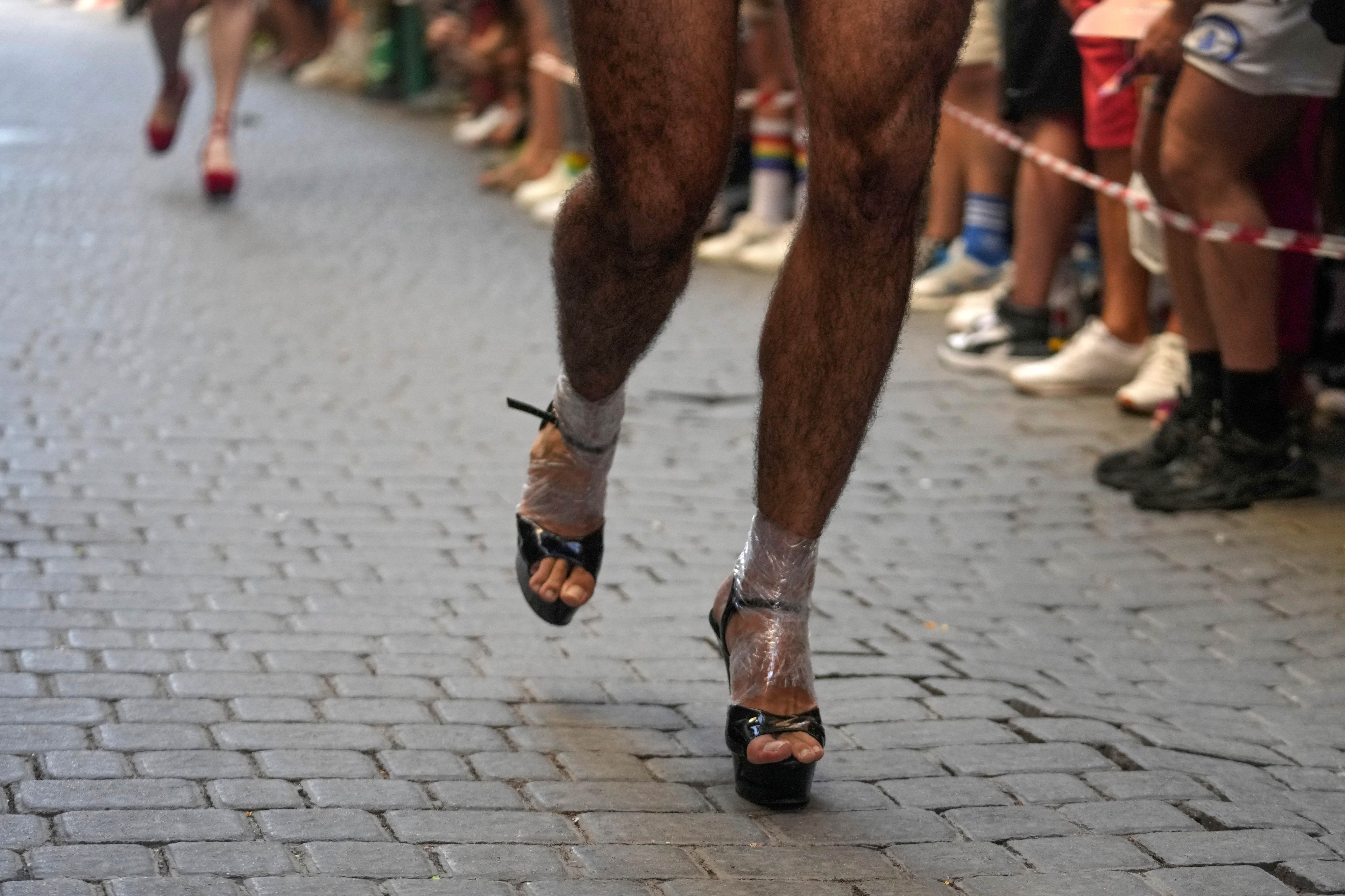 Participants compete during the Pride Week annual high heels race in the Chueca district, a popular area for the gay community in Madrid, Spain, Thursday, July 4, 2024. (AP Photo/Paul White)