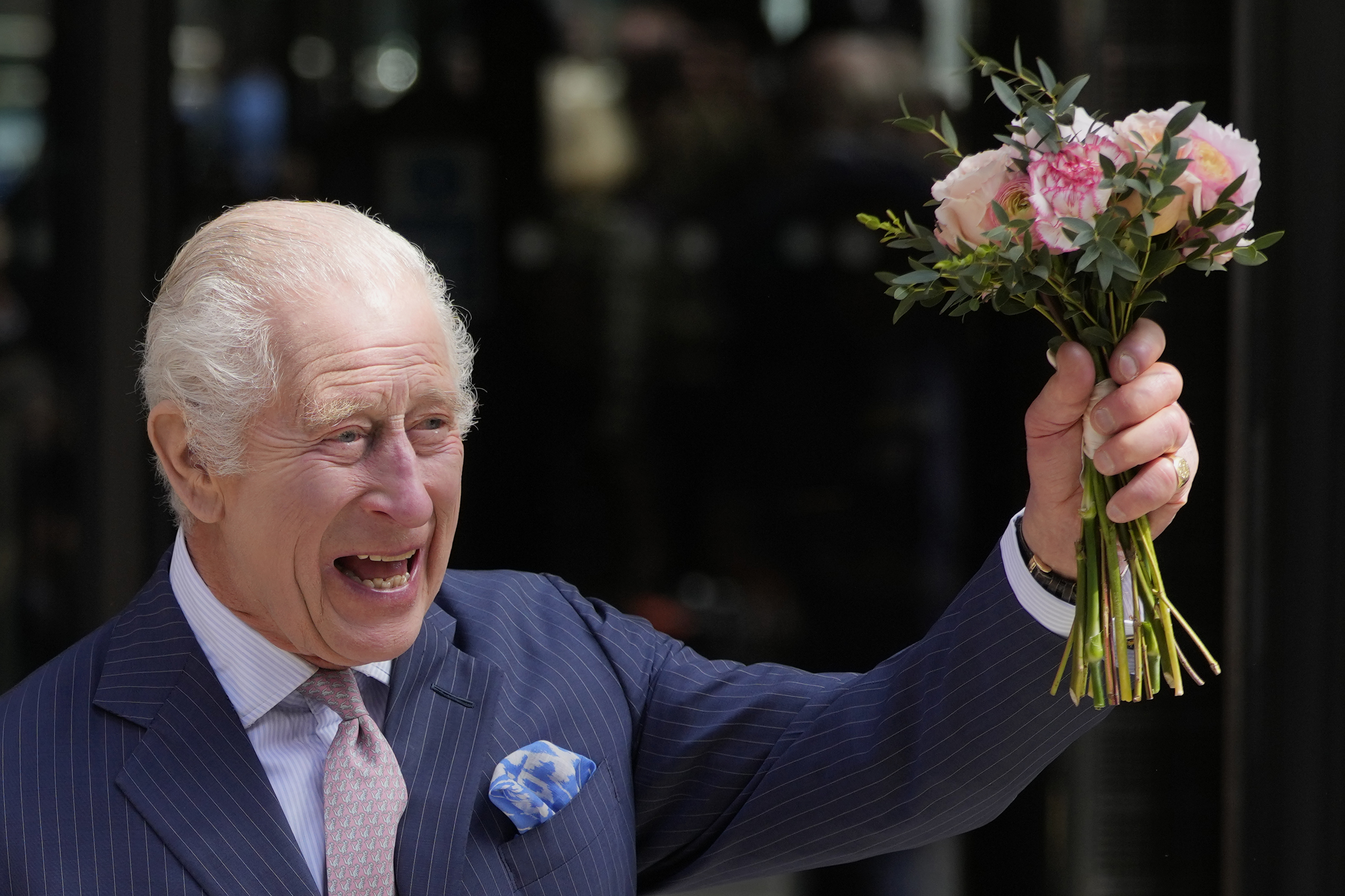 Britain's King Charles III holds up flowers he was given as he leaves after a visit to University College Hospital Macmillan Cancer Centre in London, Tuesday, April 30, 2024. The King, Patron of Cancer Research UK and Macmillan Cancer Support, and Queen Camilla visited the University College Hospital Macmillan Cancer Centre, meeting patients and staff. This visit is to raise awareness of the importance of early diagnosis and will highlight some of the innovative research, supported by Cancer Research UK, which is taking place at the hospital. (AP Photo/Kin Cheung)