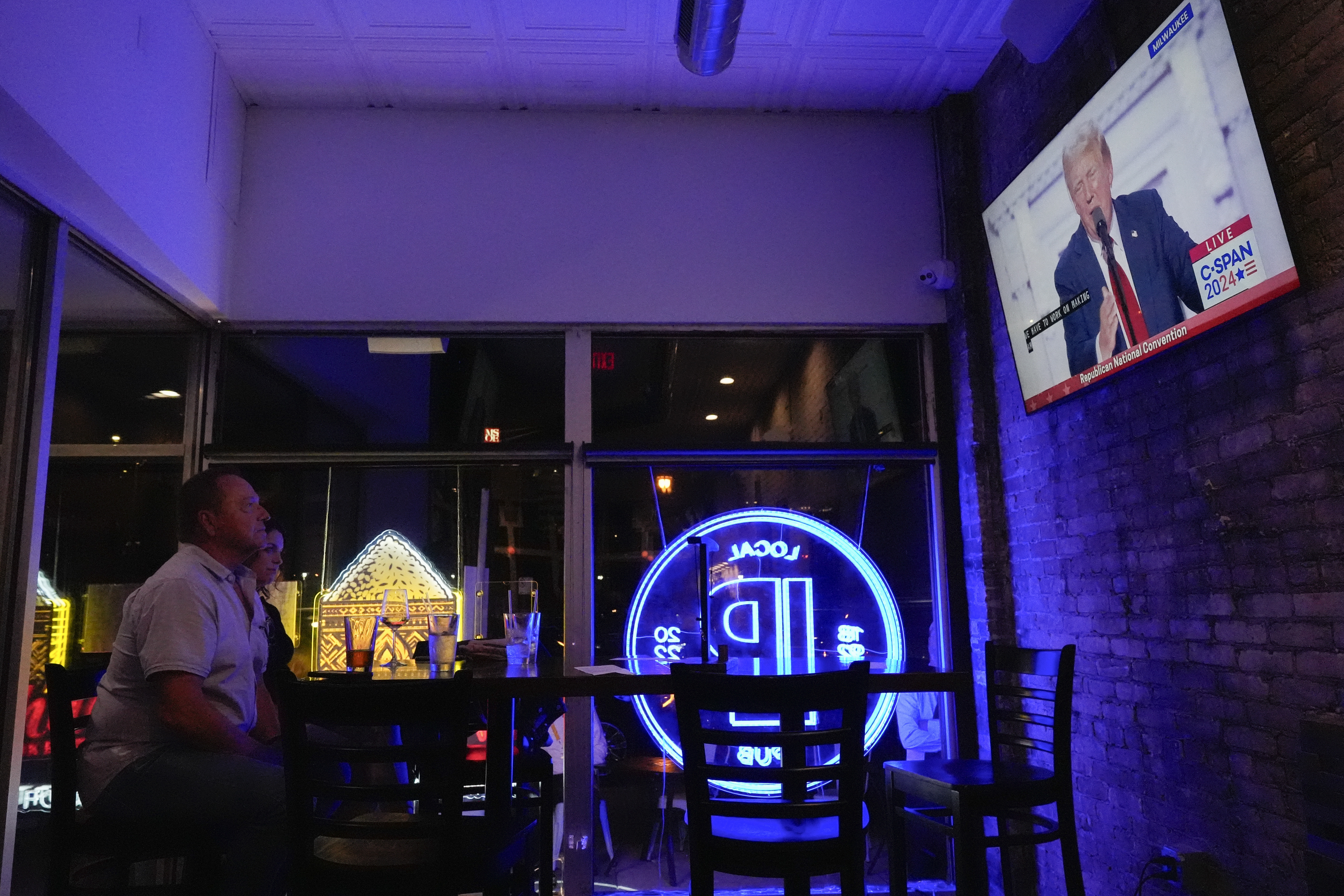 Jim, left, and Tamara Hamilton watch former President Donald Trump speak on television on Thursday, July 18, 2024, in Milwaukee. (AP Photo/Mike Stewart)