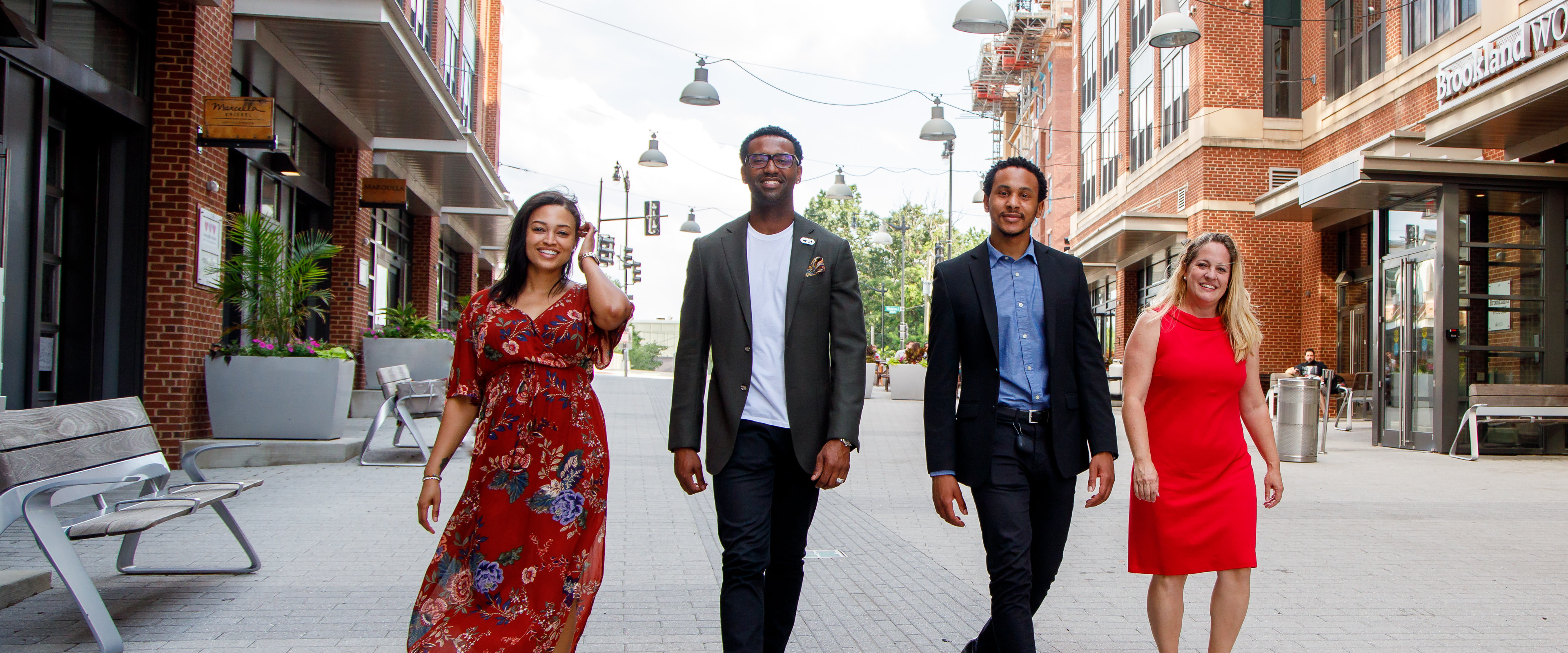 four successful professionals confidently walking down the street