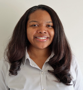 Philisa Rogers is a Black woman with long black hair. She smiles brightly wearing a white collared shirt.