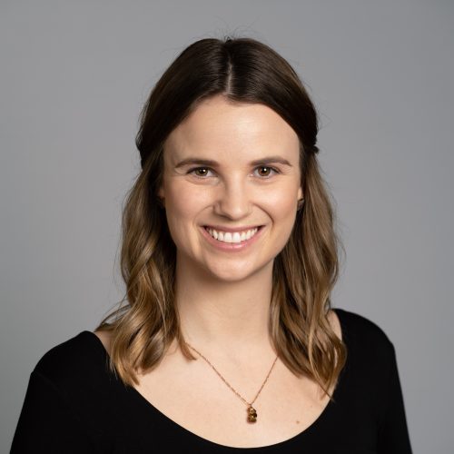 Shannon McDermott is a young White woman with long, light brown hair. She smiles brightly and wears a black blouse and pendant necklace.