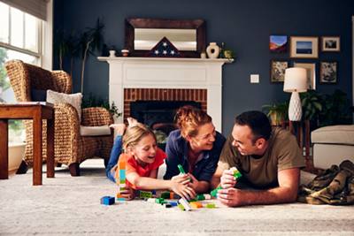 Parents and daughter in living room playing with legos