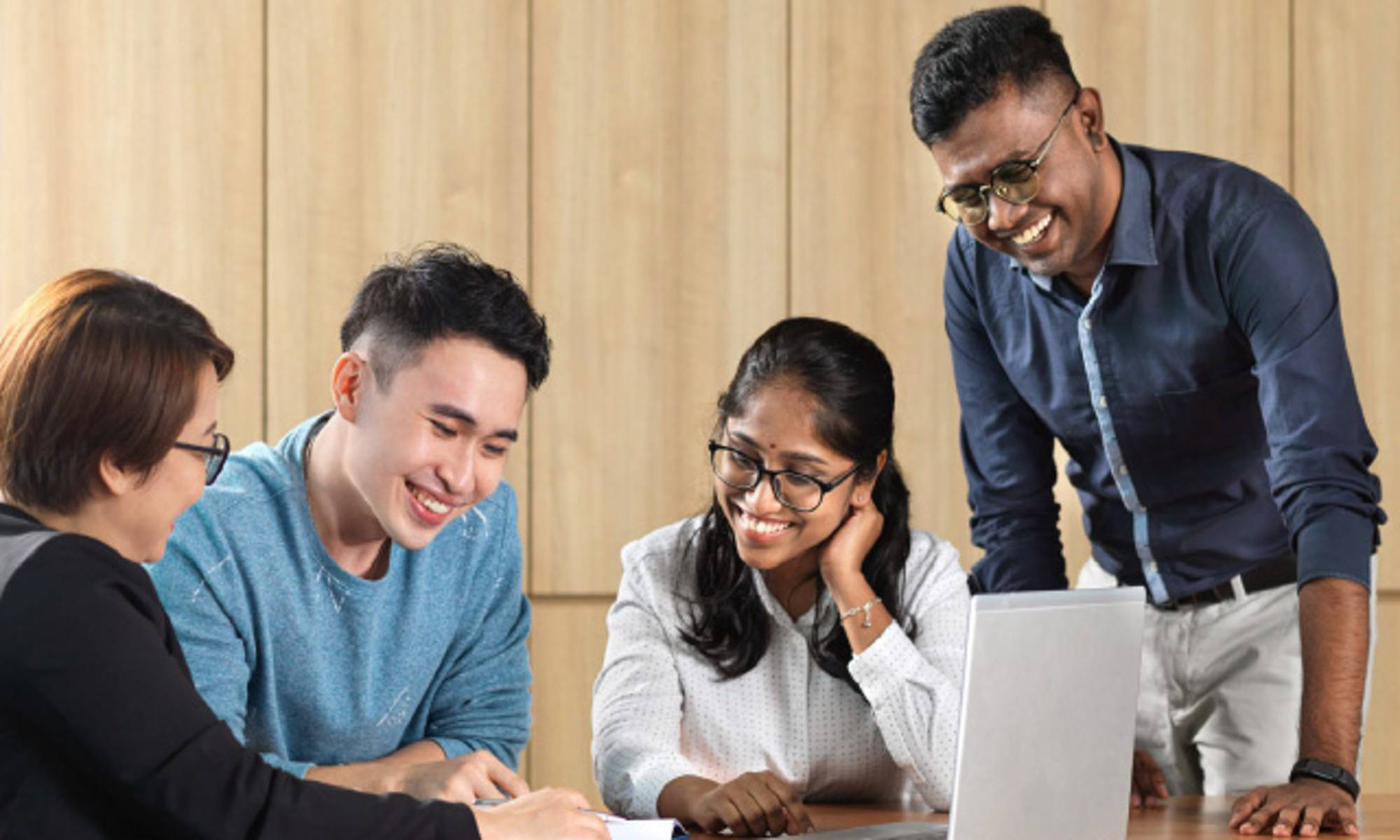 group of people having a discussion with a laptop infront of them