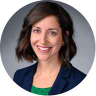 Headshot of Stephanie Smith with short brown hair, wearing a navy blazer with a gray background