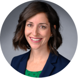 Headshot of Stephanie Smith with short brown hair, wearing a navy blazer with a gray background