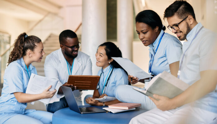 group of healthcare providers reading books and papers and talking together