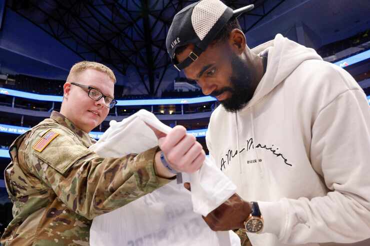 Ssgt. James Woodward holds his shirt as Dallas Mavericks forward Tim Hardaway Jr. (10) signs...