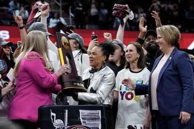 South Carolina head coach Dawn Staley, center, celebrates with the trophy after the Final...