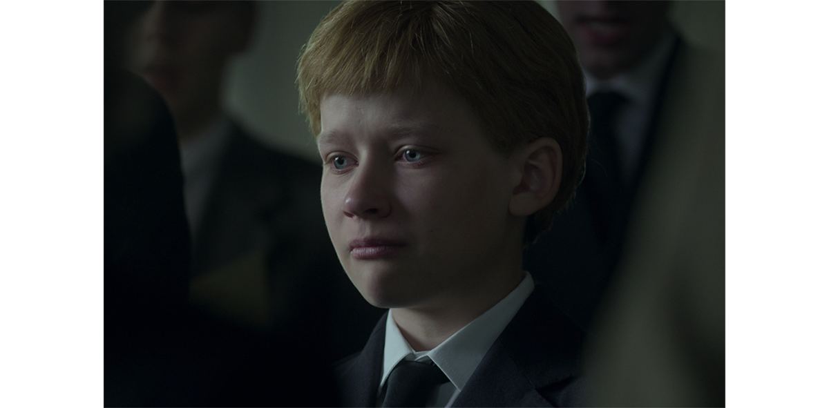 A young child in tears at a funeral