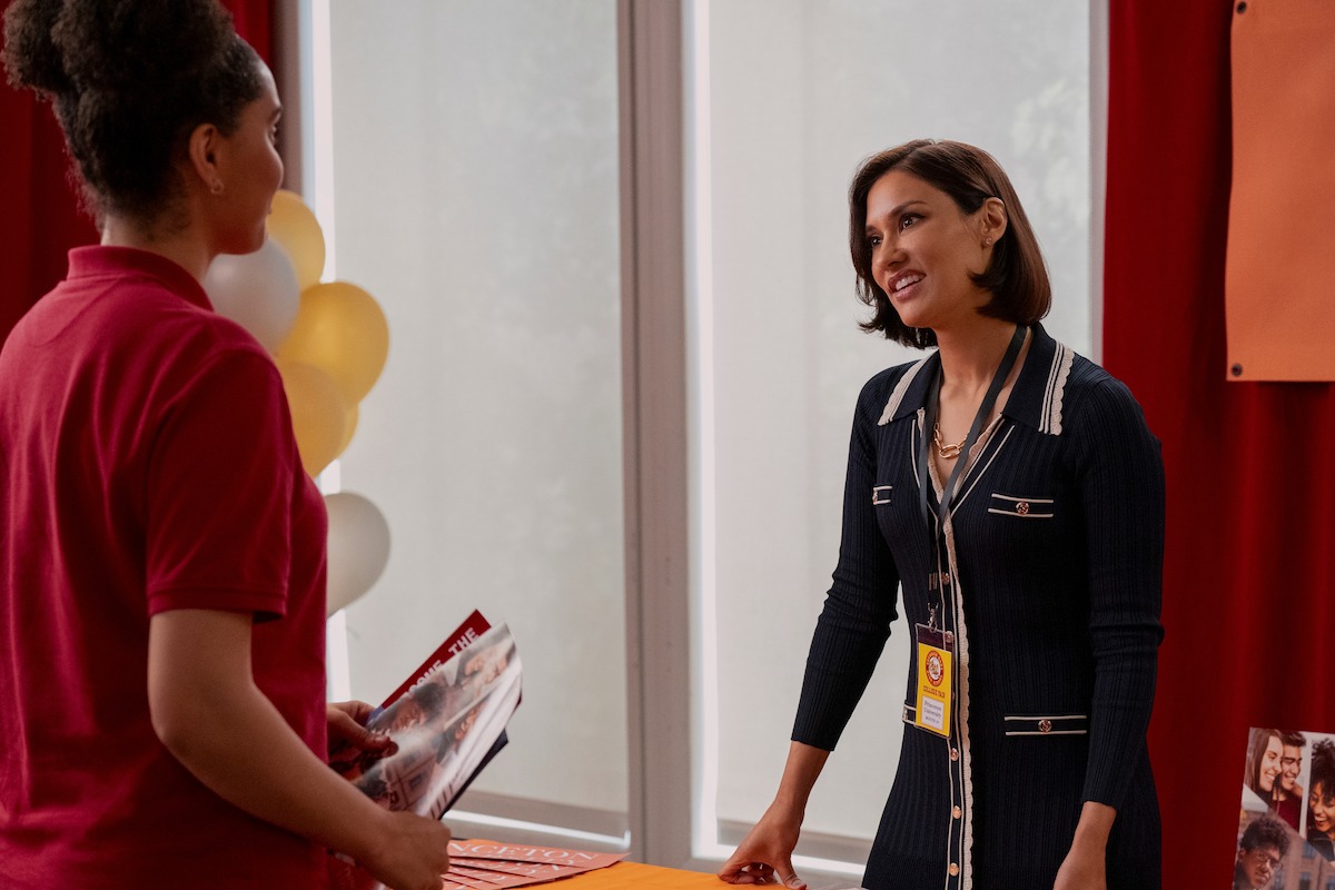 Janina Gavankar as Ashkara in ‘Never Have I Ever’ Season 4 stands at college fair. 