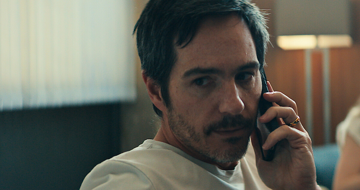 Mauricio Ochmann talks on the phone with a concerned expression in 'Non Negotiable'