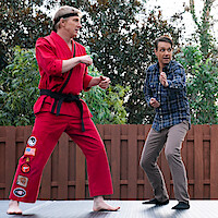 William Zabka as Johnny Lawrence, Ralph Macchio as Daniel LaRusso, and Yuji Okumoto as Chozen in stand in fighting positions in Season 6 of 'Cobra Kai'