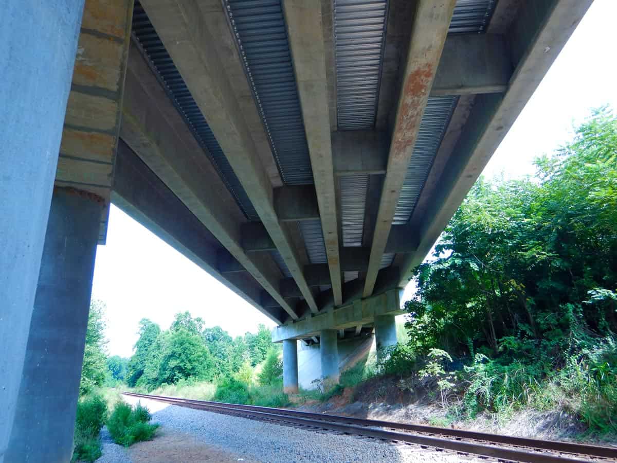 photo of underneath bridge going over railroad tracks