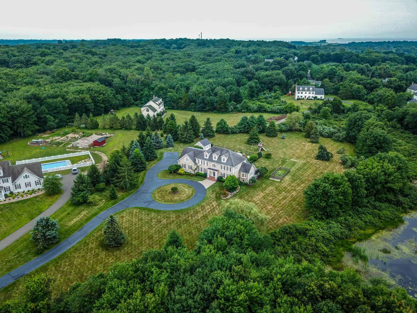 aerial drone photo of house with mown lawn and pine trees in Connecticut