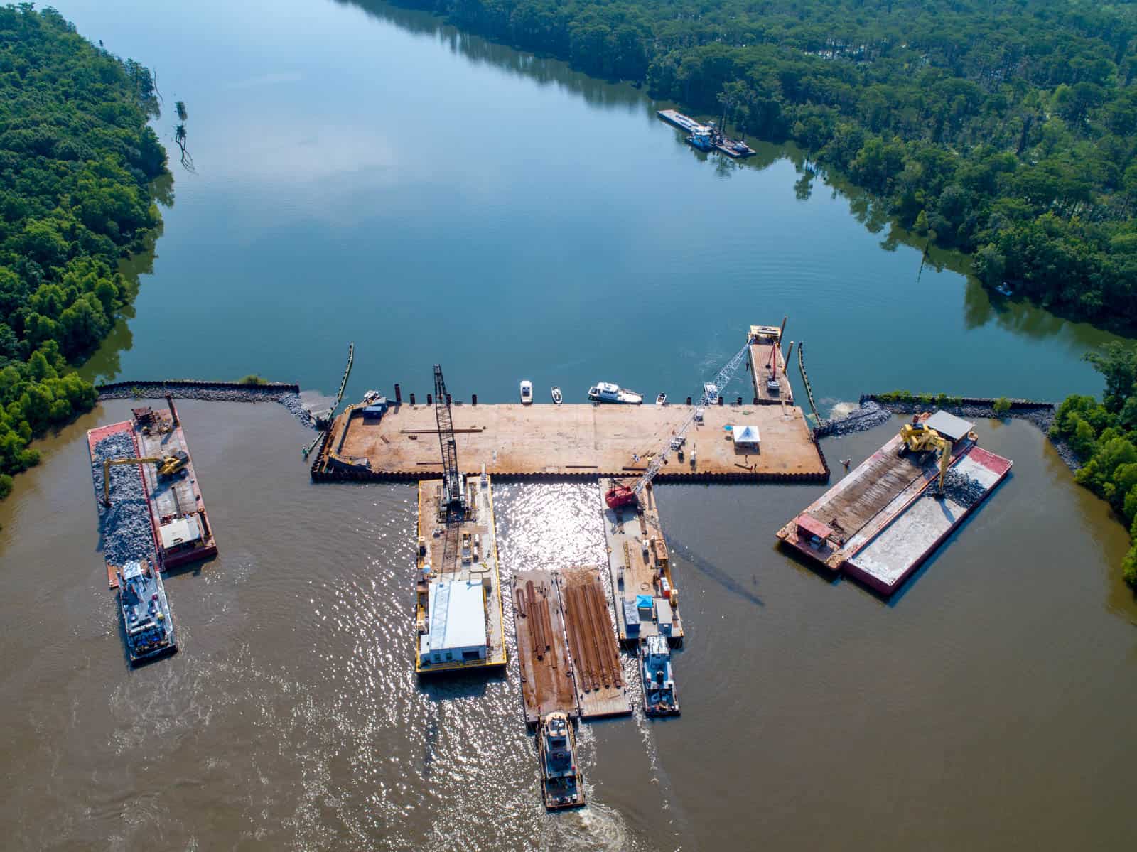 Aerial drone photo of boats on water building dam and cleaning water in Amelia, LA