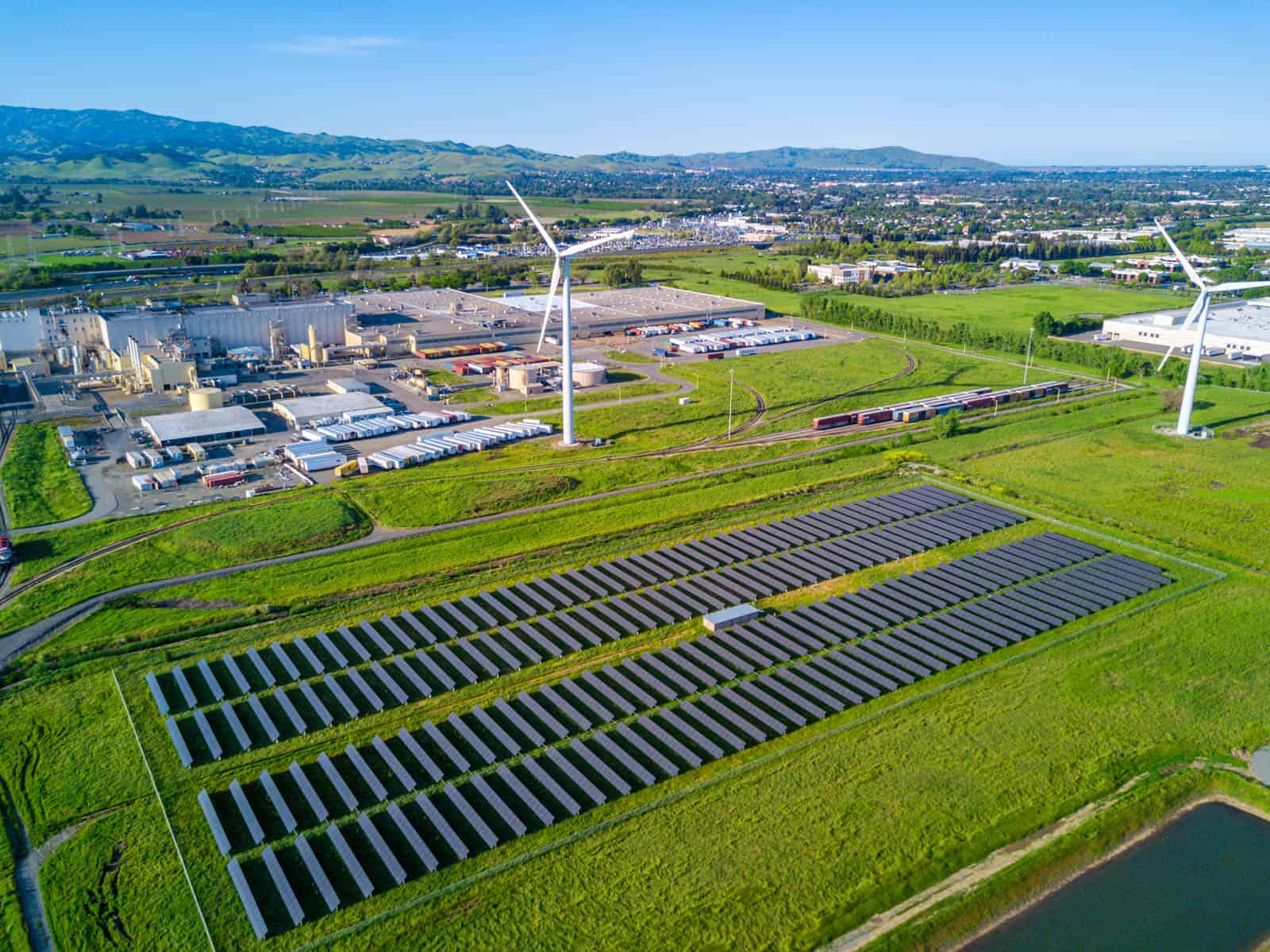 drone photo of solar panel field near two windmills in Fairfield, CA