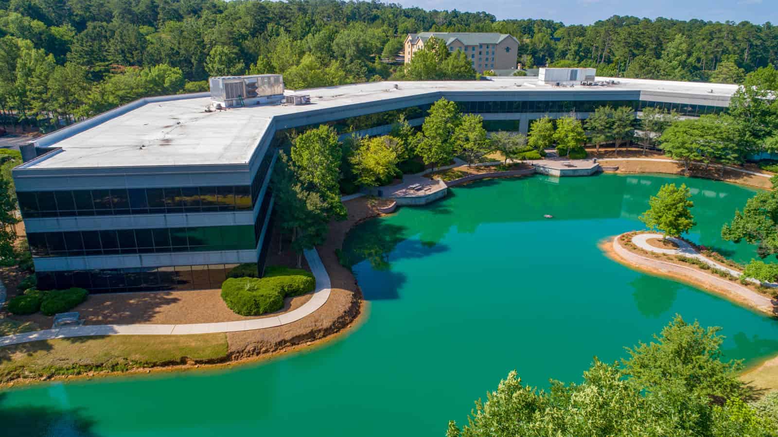 drone photo of office building with vibrant green pond video in foreground in Birmingham, Alabama