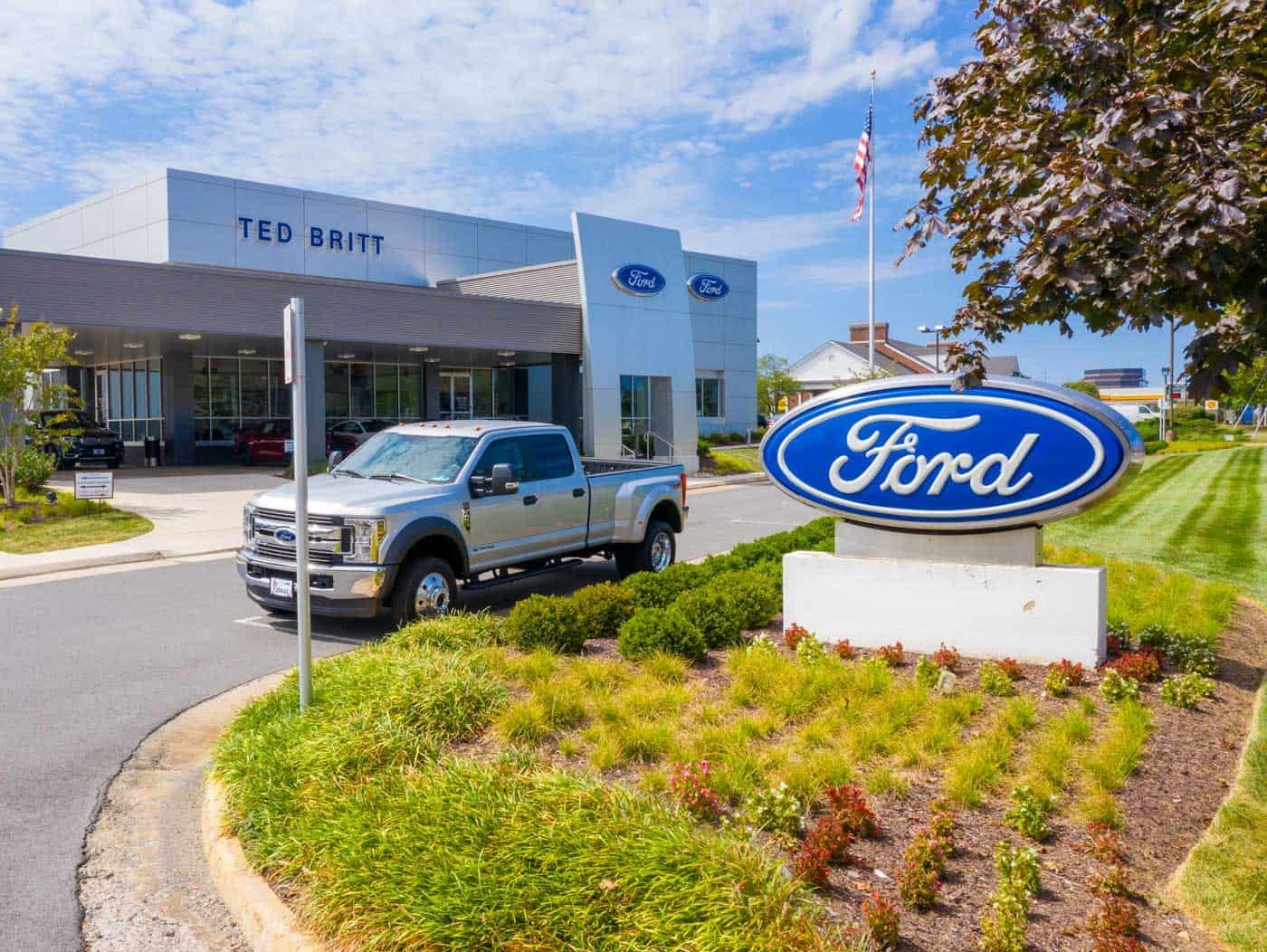 low altitude drone photo of front of Ford dealership with F150 truck parked in front in Fairfax, VA