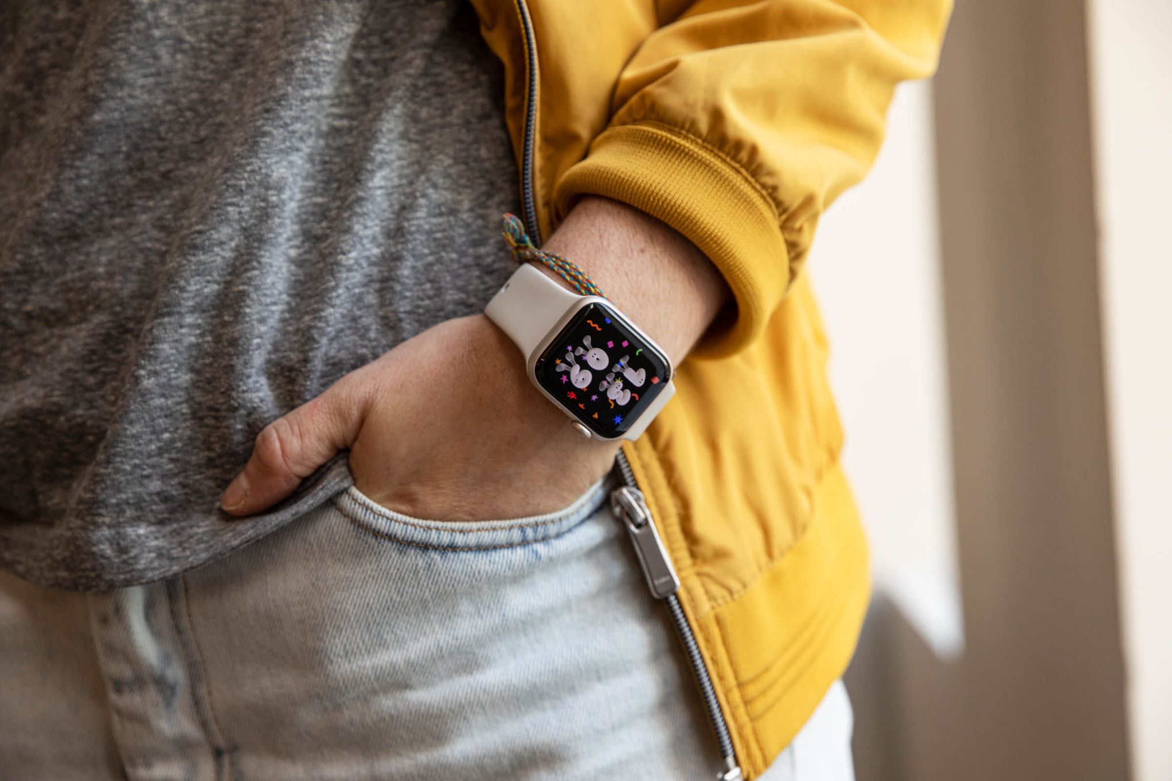 Man in yellow jacket models Apple Watch SE (2022)