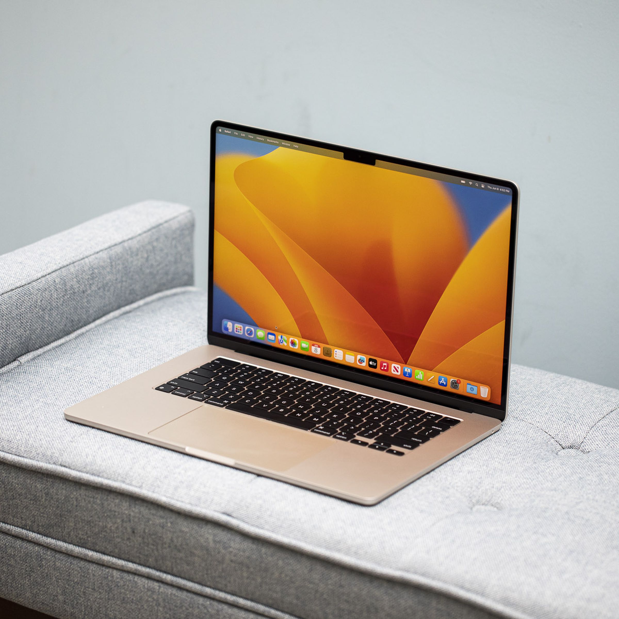 Best Laptop 2023: A Starlight MacBook Air 15-inch open on a gray couch.