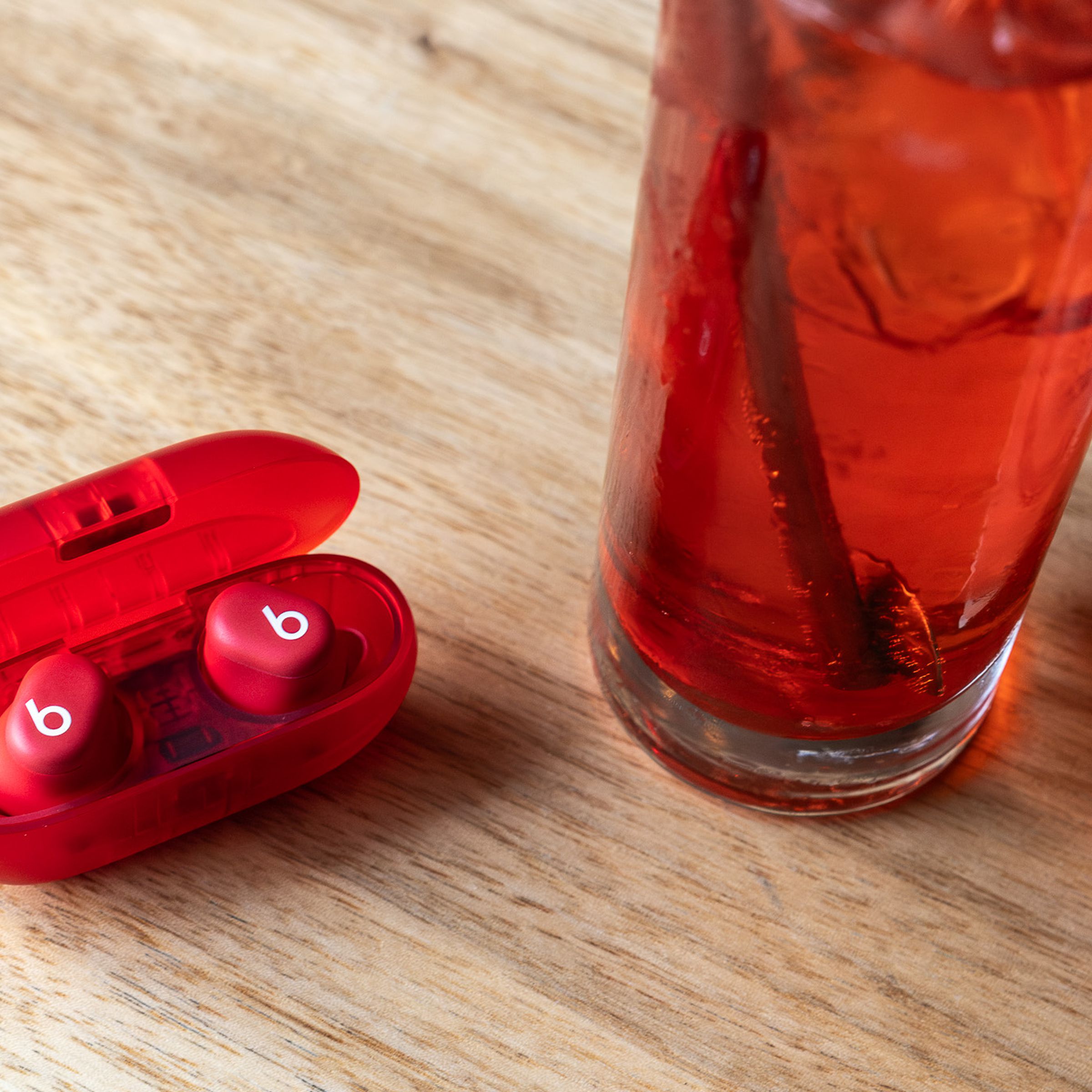 A photo of the Beats Solo Buds next to a cocktail drink.