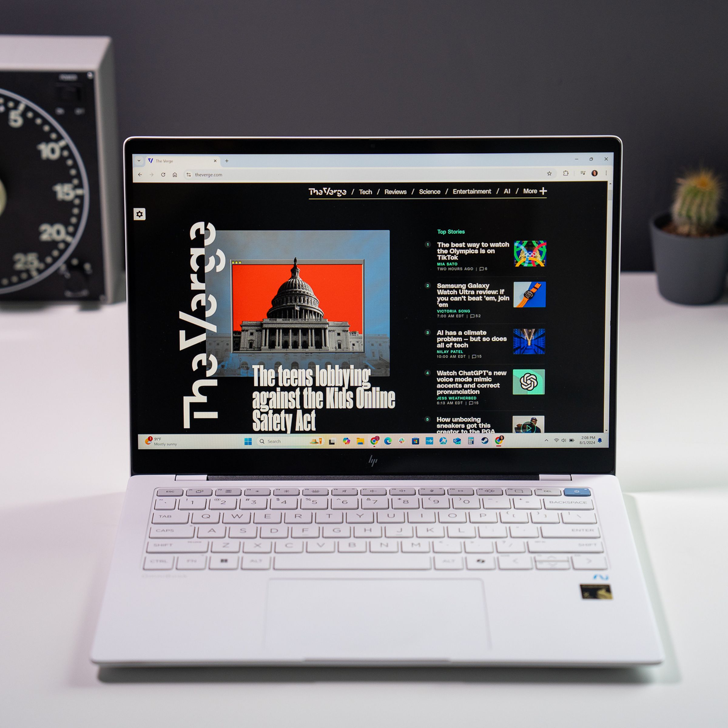 A white HP OmniBook X laptop sitting on a white tabletop in front of desk accessories.