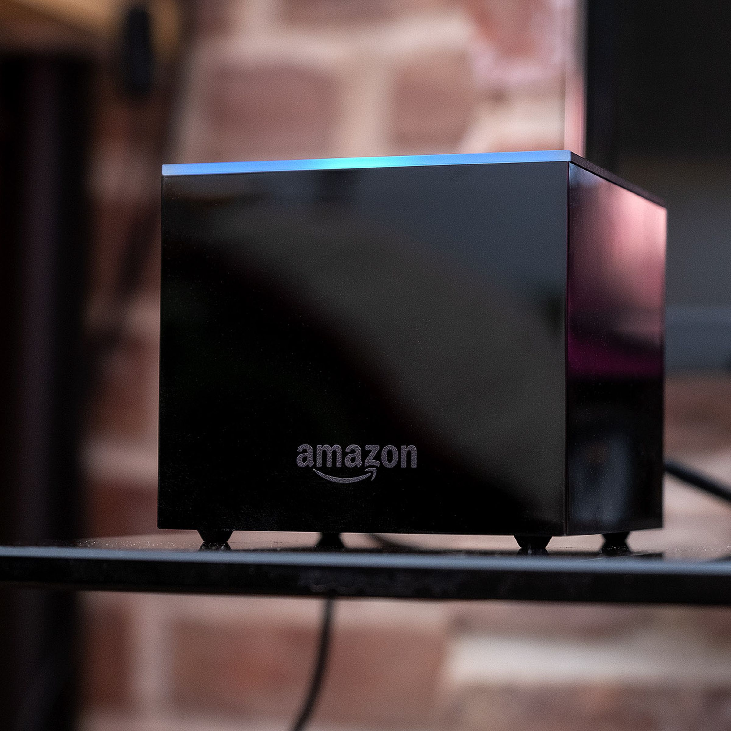 Amazon’s Fire TV Cube, the best streaming player if you don’t have a smart speaker, pictured on a TV stand.