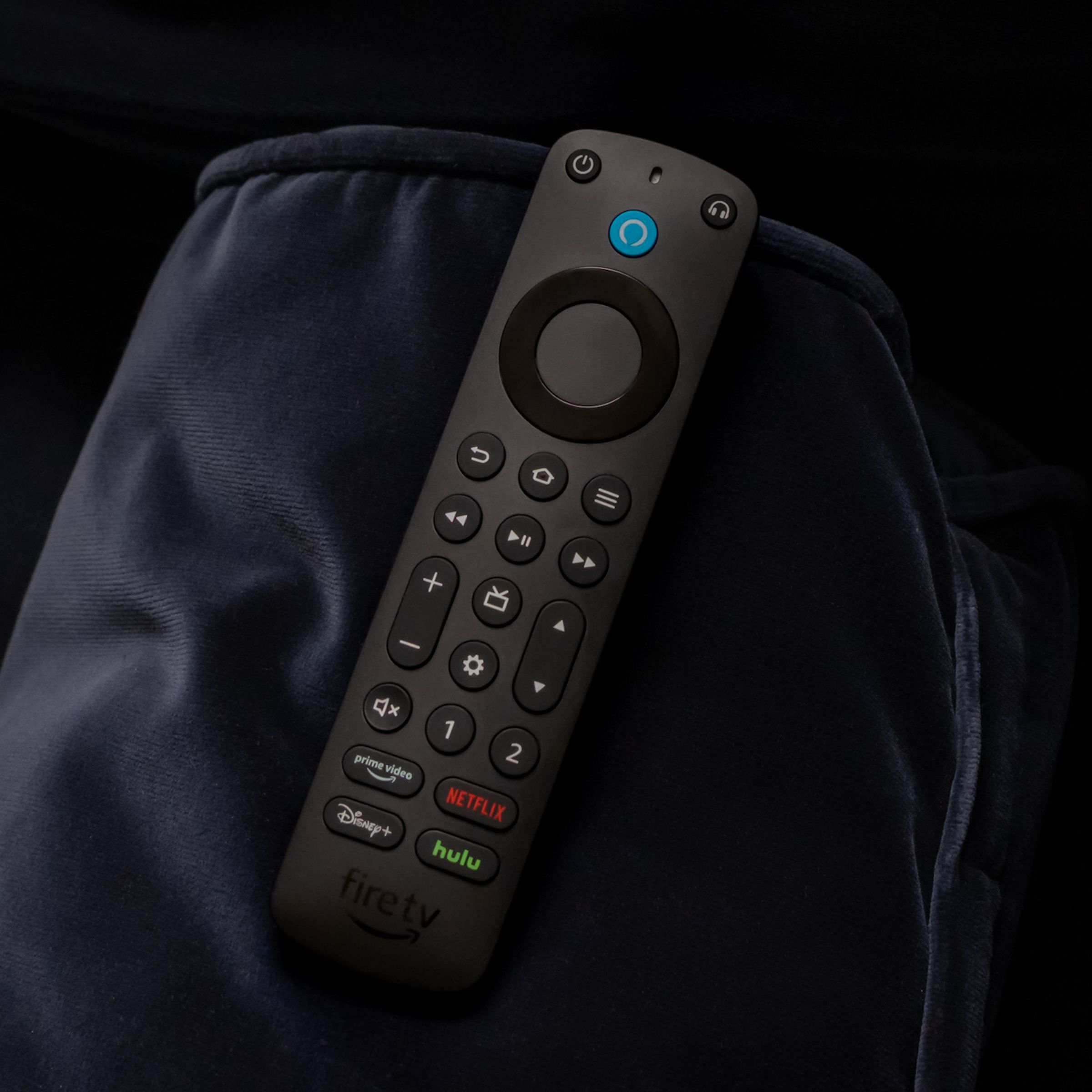 A photo of the Amazon Alexa Voice Remote Pro on a couch arm.