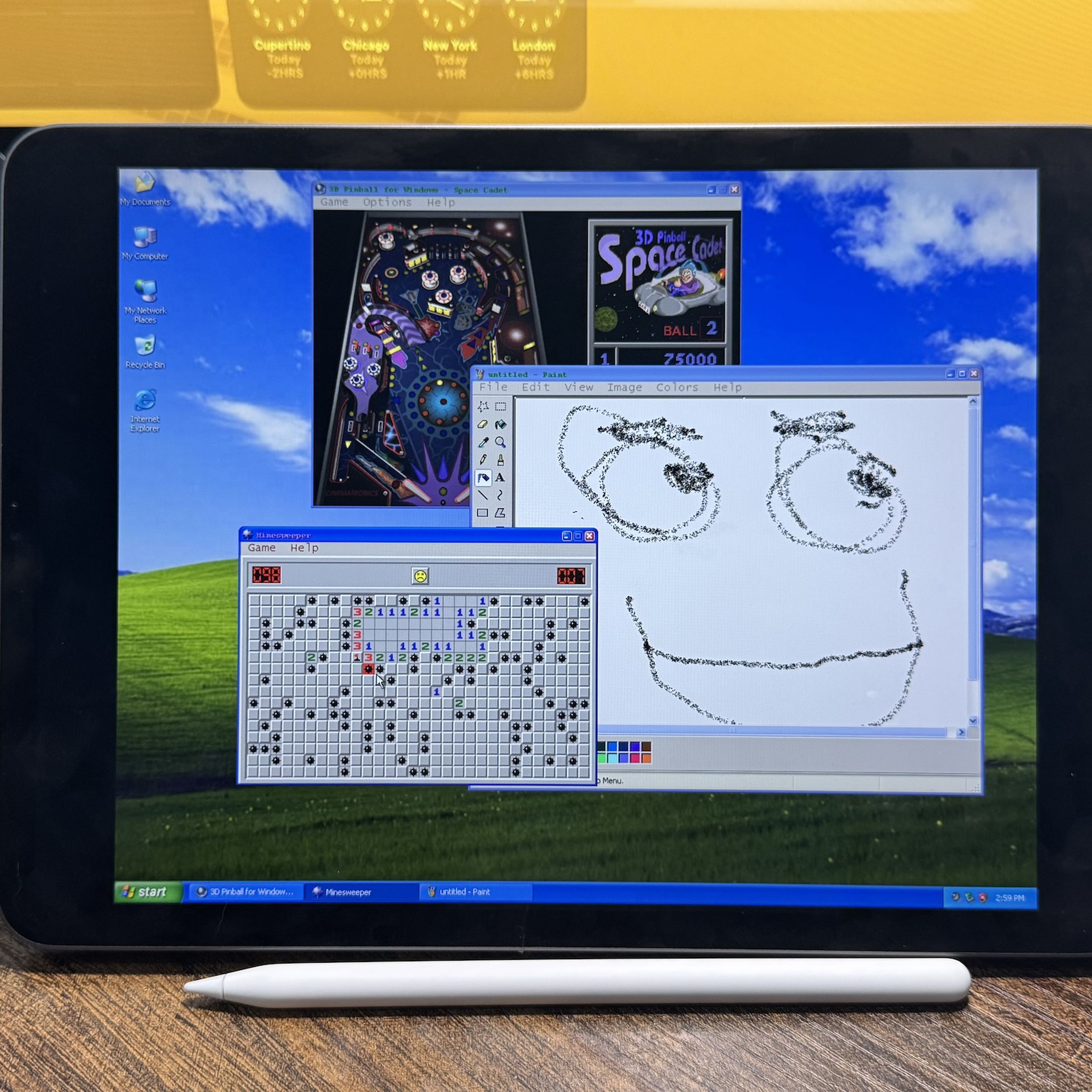 A picture of an iPad running Windows XP, with Minesweeper, 3D Pinball, and MS Paint on the screen.