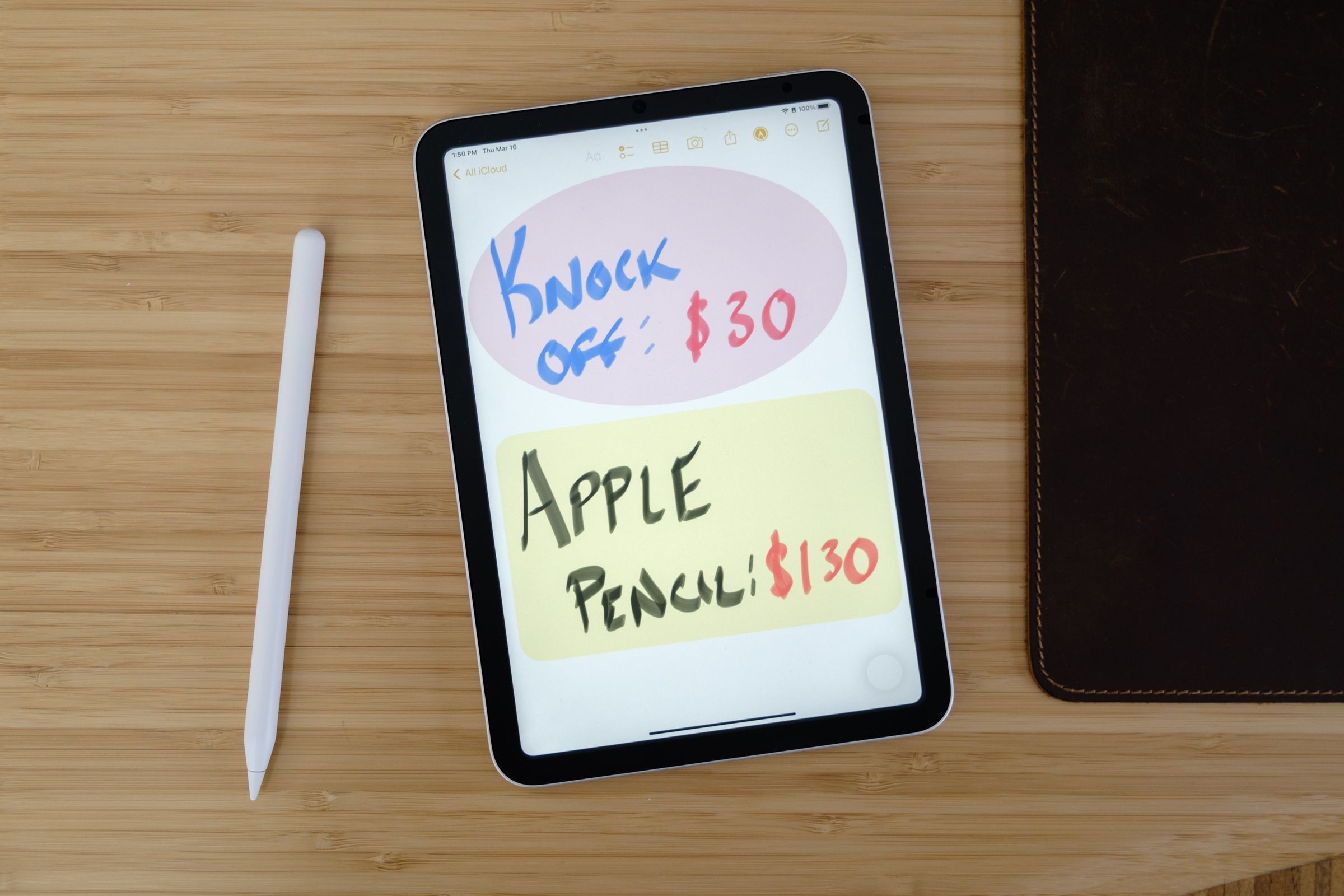 An Apple Pencil-like stylus next to an iPad Mini displaying artwork saying Knockoff: $30 Apple Pencil: $130