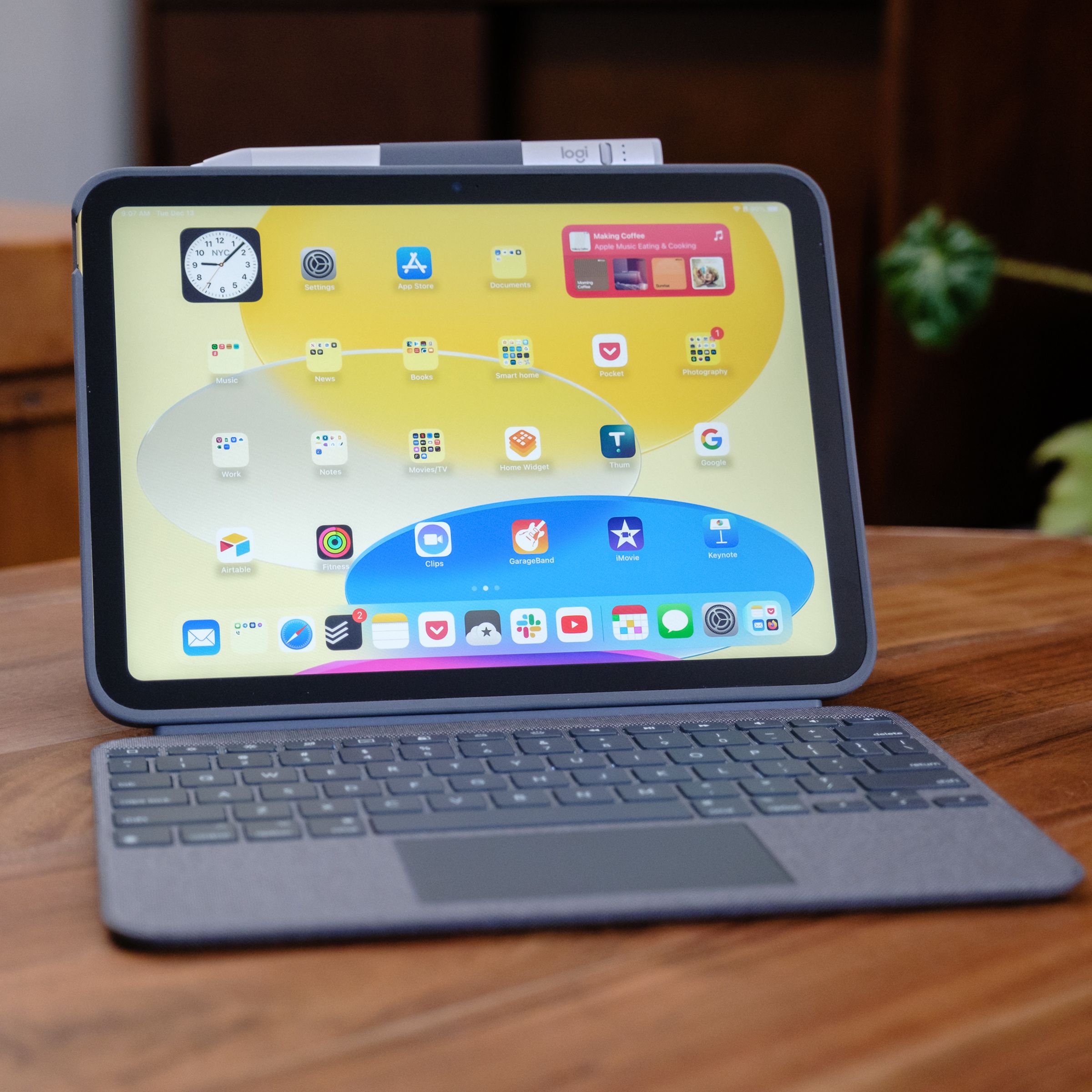 A 10th Gen iPad in a Logitech Combo Touch keyboard case on a wood table.