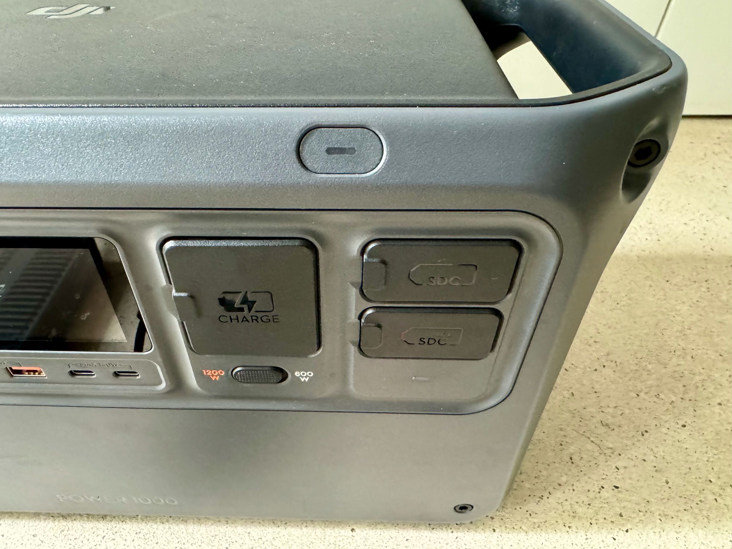 <em>The AC input and SDC ports are protected with plastic flaps. You can see the fast charge switch that lets you jump from 600W to 1200W AC charging from a wall outlet.</em>