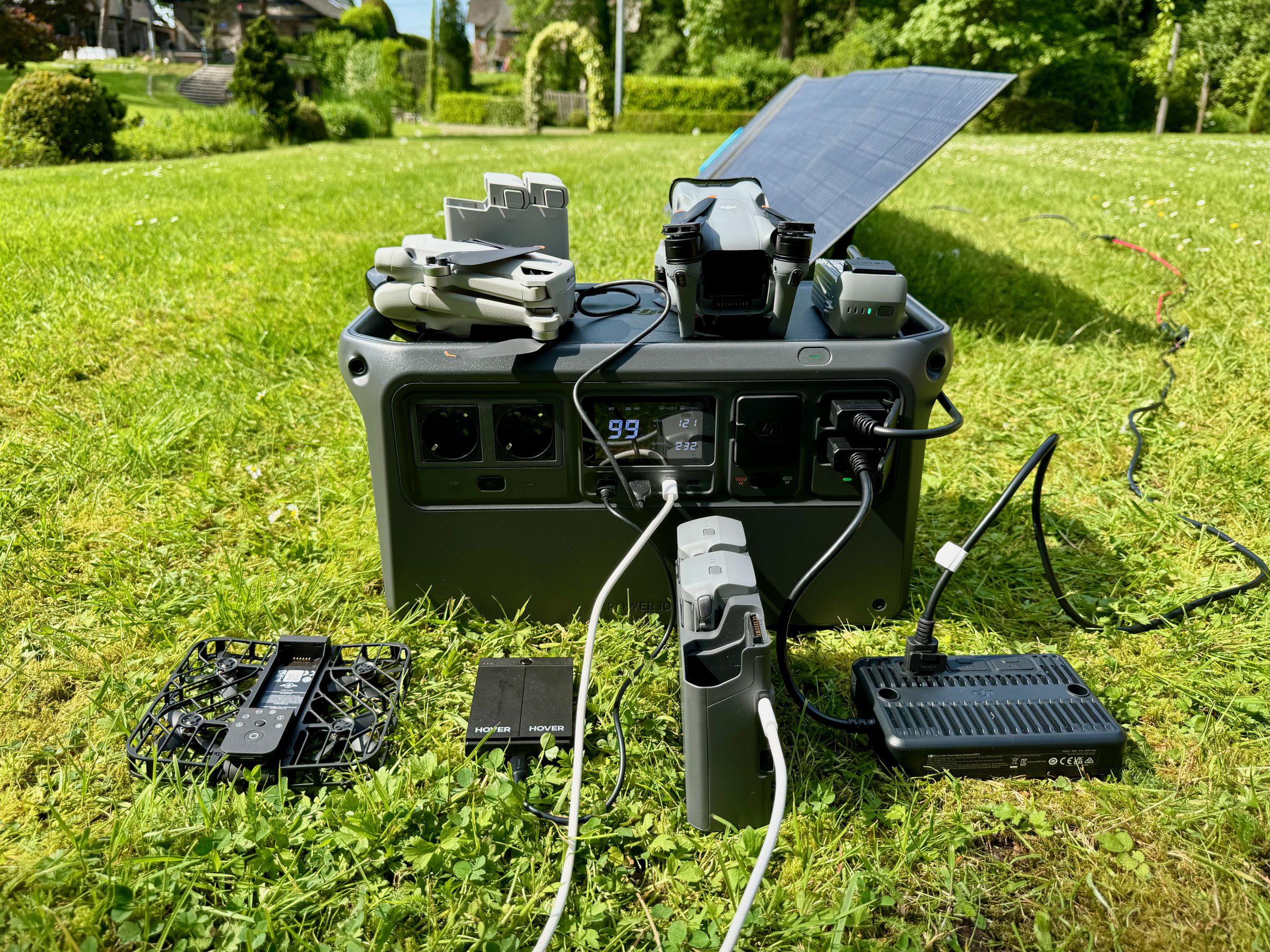 The DJI Power 1000 charging a Hover Air X1’s battery hub over USB-A, the DJI Mini 3 Pro’s battery hub over USB-A, the DJI Air 3’s battery hub over faster USB-C, and a single Air 3 battery via fast SDC port. The power station is also charging via a 200W Bluetti solar panel connected to the SDC-to-MPPT solar controller adapter. On the display, you can see 232W going out to the devices and 121W of solar trying to keep the Power 1000 charged.