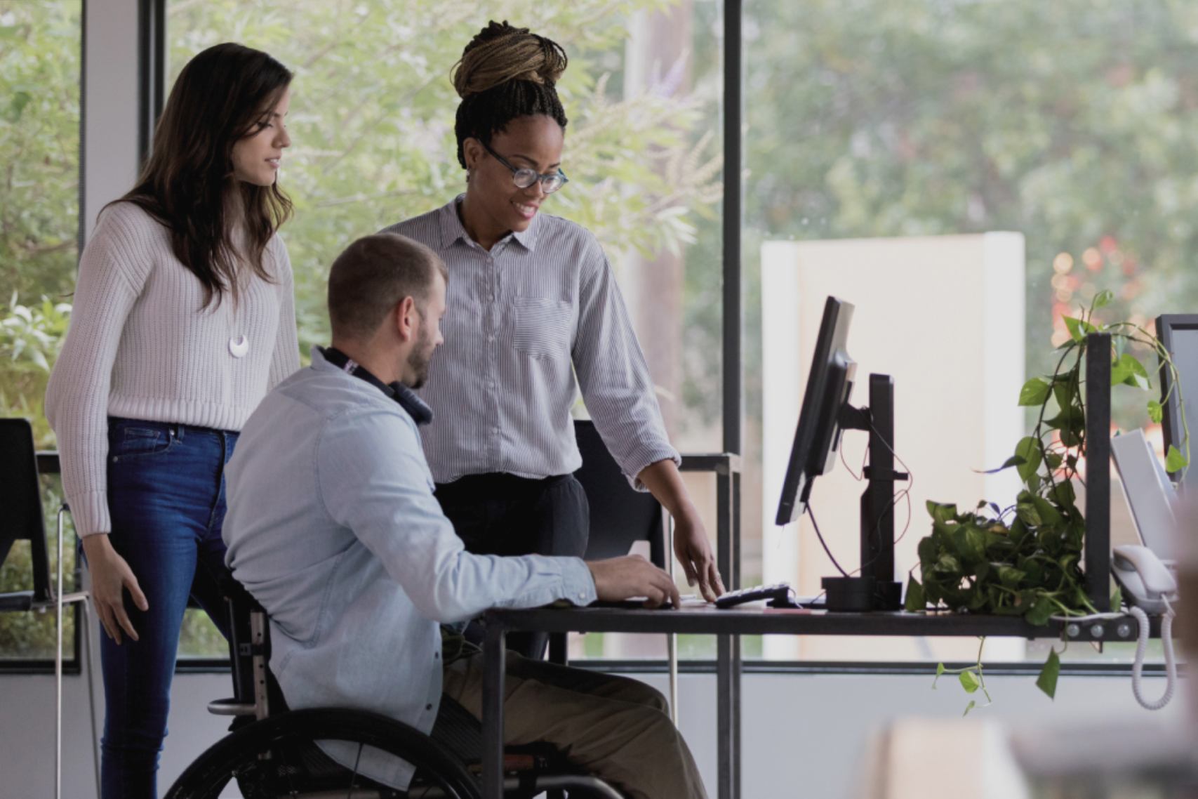 Employees discussing in front of computer