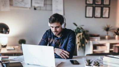 Man wearing headphone in front of laptop