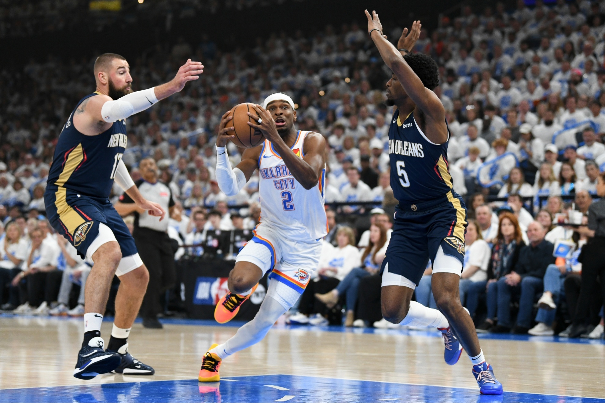 Thunder guard Shai Gilgeous-Alexander (2) drives past Pelicans center Jonas Valanciunas, left, and forward Herbert Jones (5).