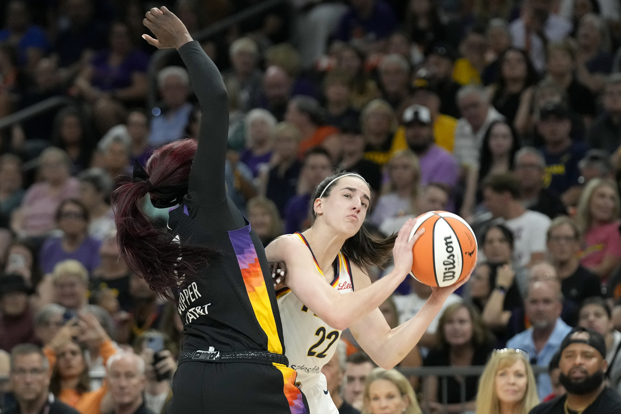 Indiana Fever guard Caitlin Clark (22) goes up to shoot against Phoenix Mercury guard Kahleah Copper during the first half of a WNBA basketball game.