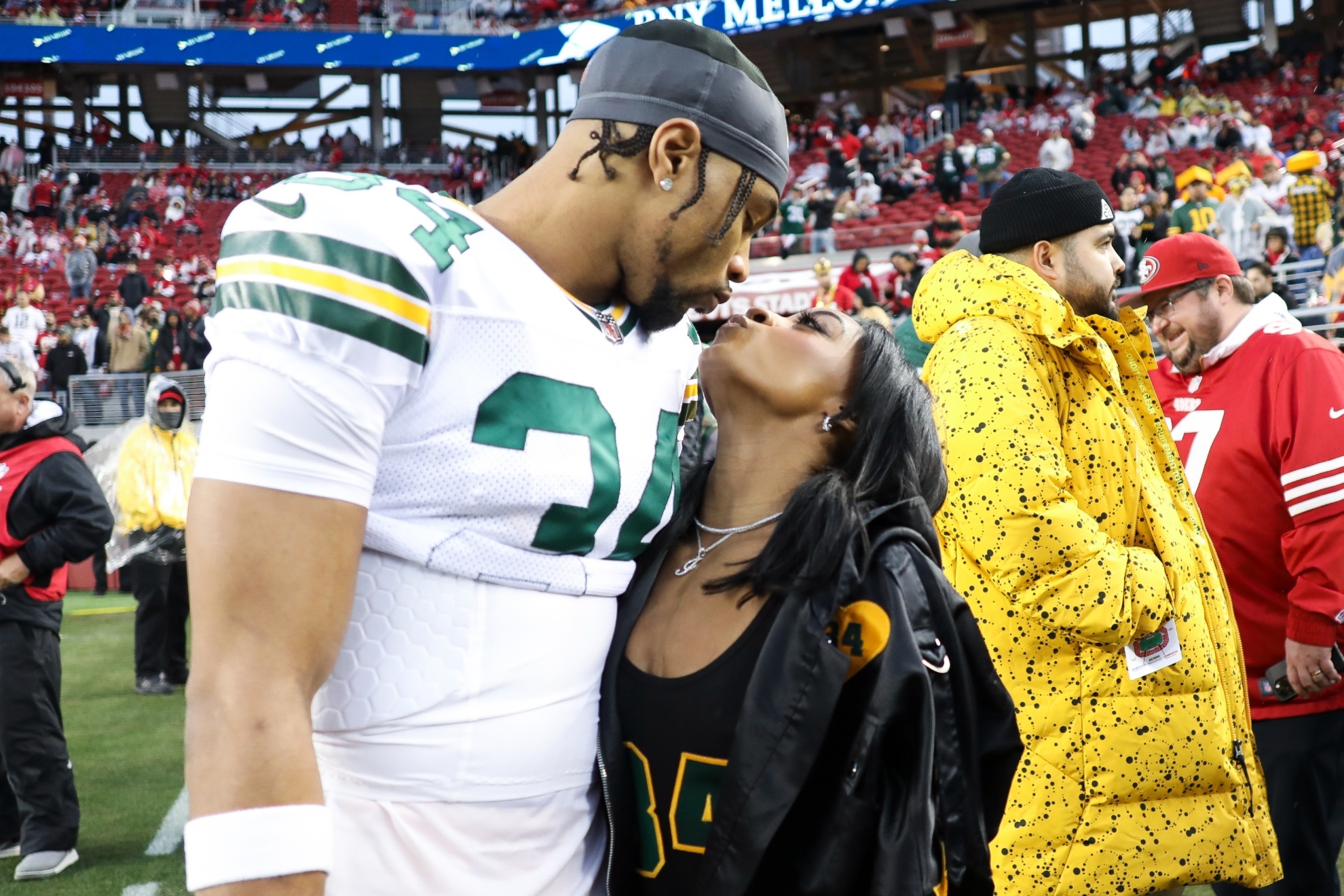 Green Bay Packers safety Jonathan Owens (34) and Simone Biles kiss before an NFL football NFC divisional playoff game between the Packers and the San Francisco 49ers, Saturday, Jan. 20, 2024, in Santa Clara, Calif. (AP Photo/Jed Jacobsohn)