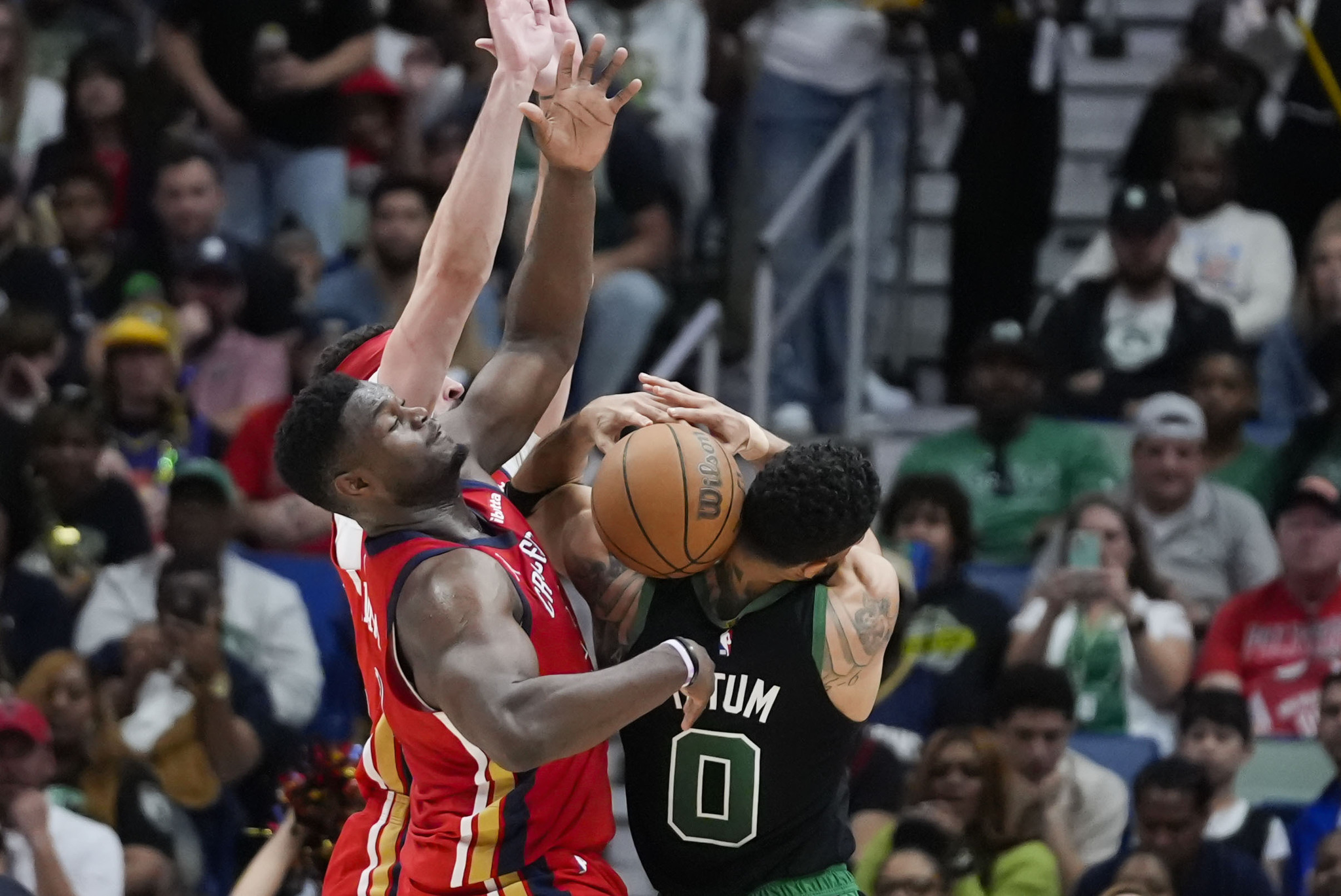 Boston Celtics forward Jayson Tatum (0) loses the ball under pressure from New Orleans Pelicans forward Zion Williamson (1) in the first half of an NBA basketball game