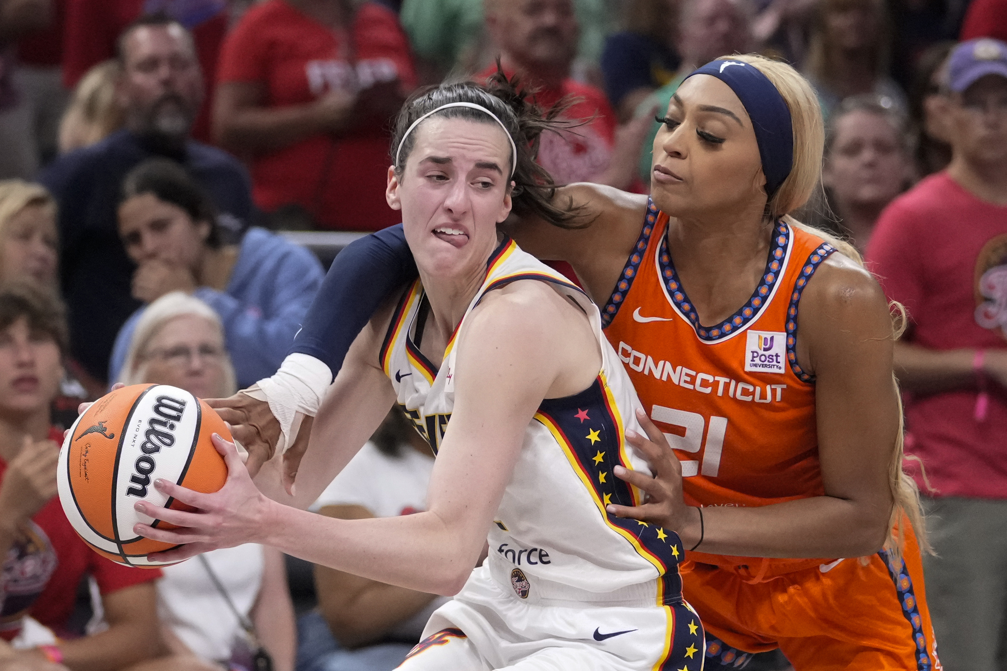 Connecticut Sun guard DiJonai Carrington (21) fouls Indiana Fever guard Caitlin Clark (22)