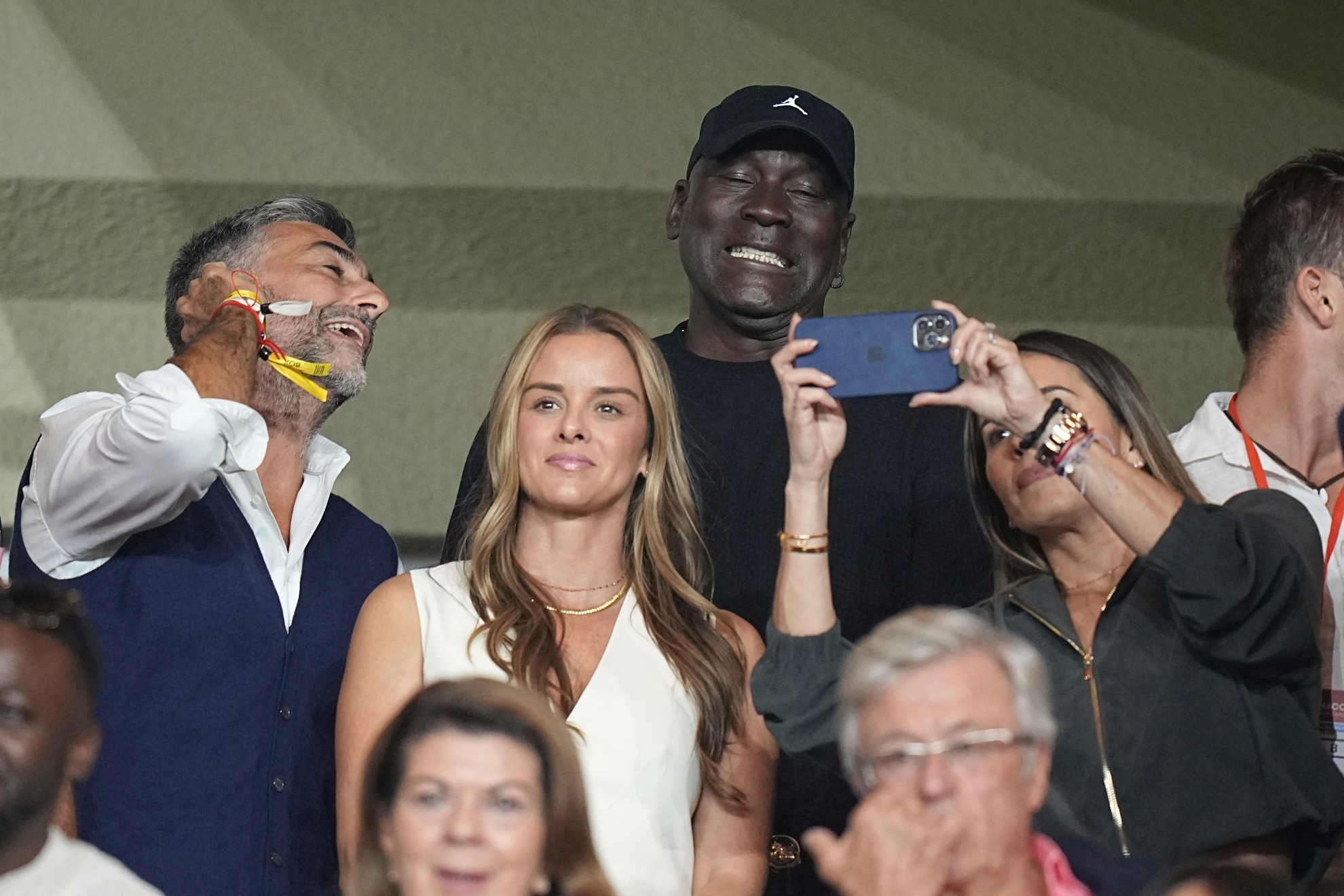 American former professional basketball player Michael Jordan, center, gestures as he poses for a selfie while attend the start of the Champions League opening phase soccer match between Monaco and Barcelona at the Louis II stadium, in Monaco, Monaco,